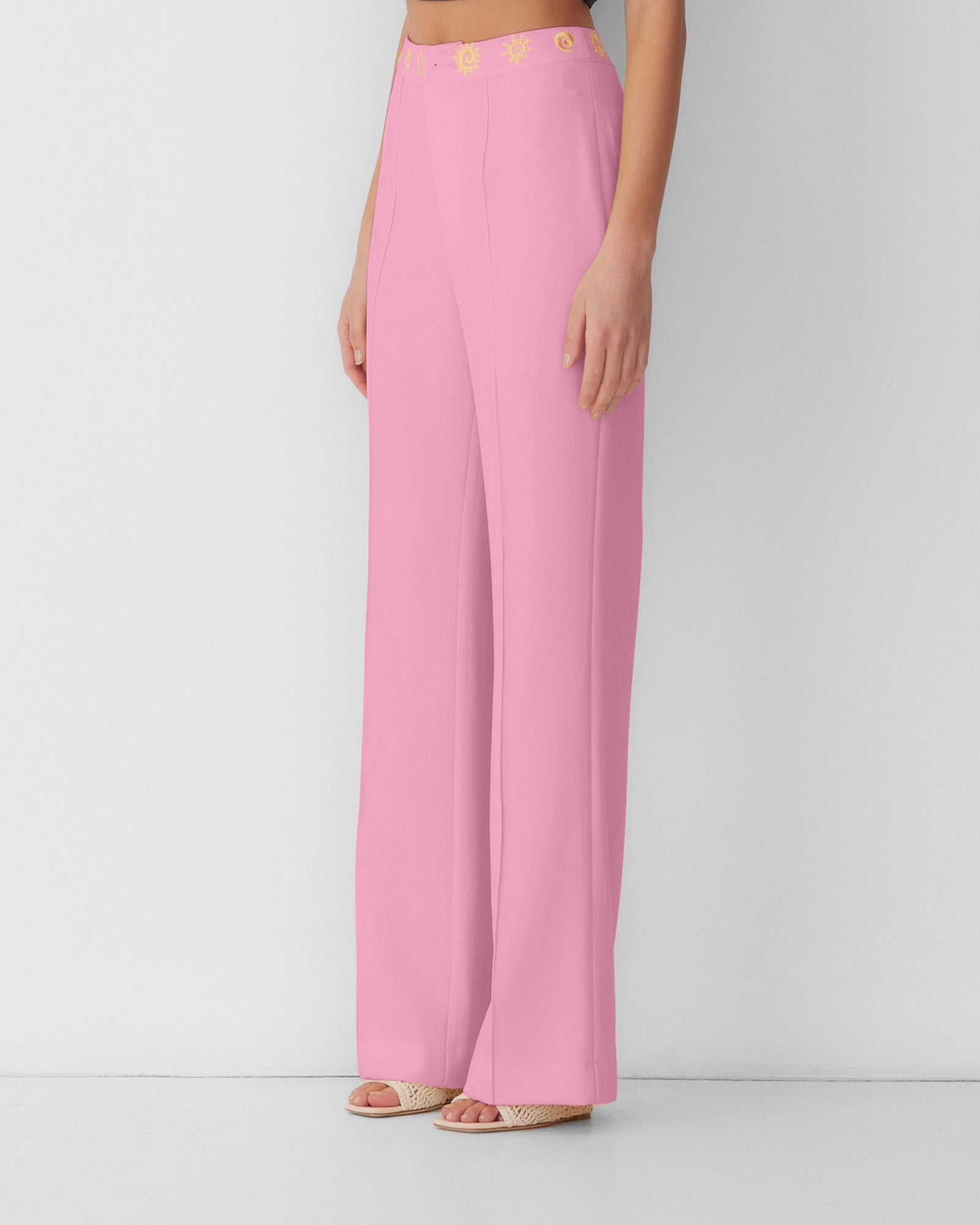 Women’s highwaisted Candy Pink Irida Bootcut Pants with pin tuck detail and embroidered waistband—wear solo or as a matching set with Irida Vest Dress.