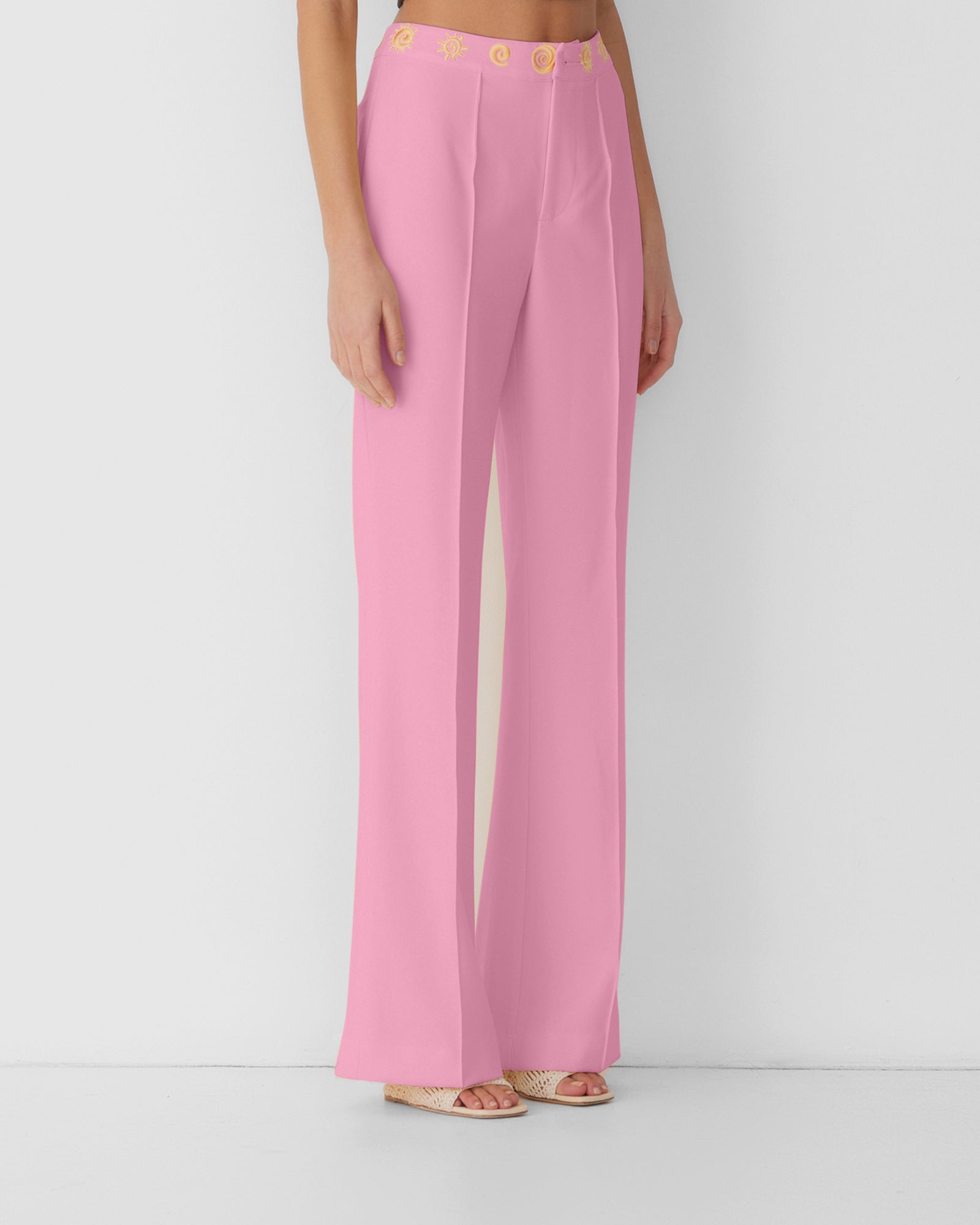 Women’s highwaisted Candy Pink Irida Bootcut Pants with pin tuck detail and embroidered waistband—wear solo or as a matching set with Irida Vest Dress.