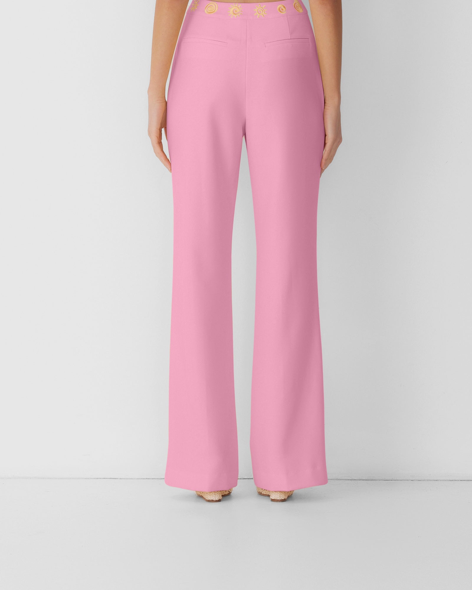Women’s highwaisted Candy Pink Irida Bootcut Pants with pin tuck detail and embroidered waistband—wear solo or as a matching set with Irida Vest Dress.