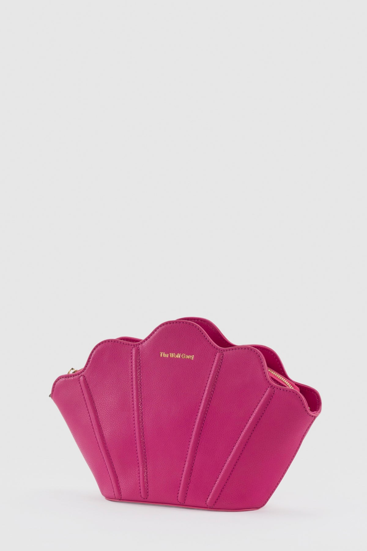 Luxury pebbled leather Suri Bag shell-shaped clutch in Flamingo Pink, with scalloped edge, gold zip, detachable crossbody strap, and ridged detail.