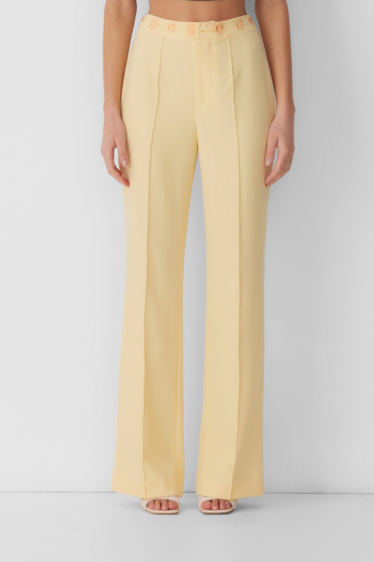 Women’s highwaisted Butter Yellow Irida Bootcut Pants with pin tuck detail and embroidered waistband—wear solo or as a matching set with Irida Vest Dress.