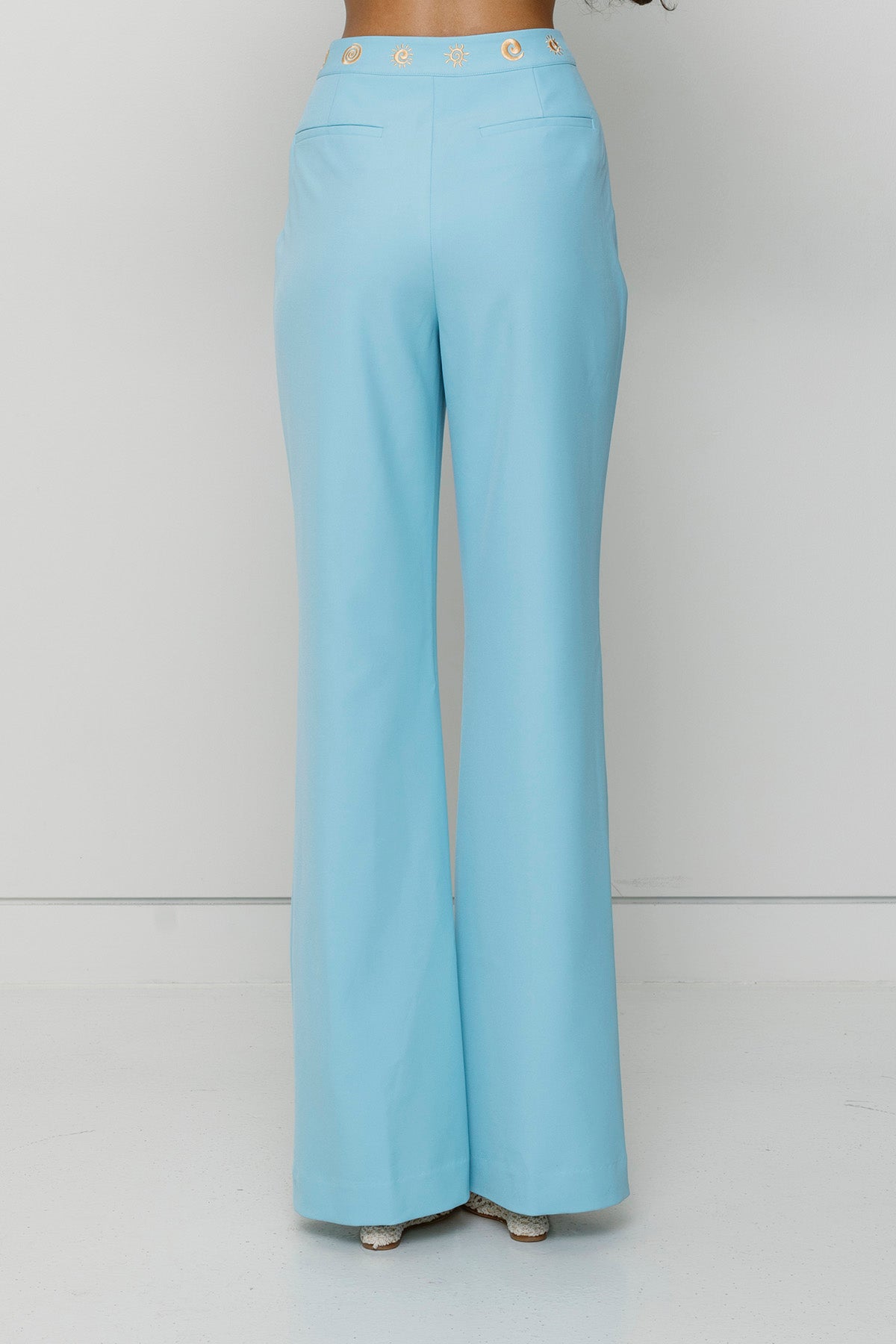 Women’s highwaisted Sky Blue Irida Bootcut Pants with pin tuck detail and embroidered waistband—wear solo or as a matching set with Irida Vest Dress.