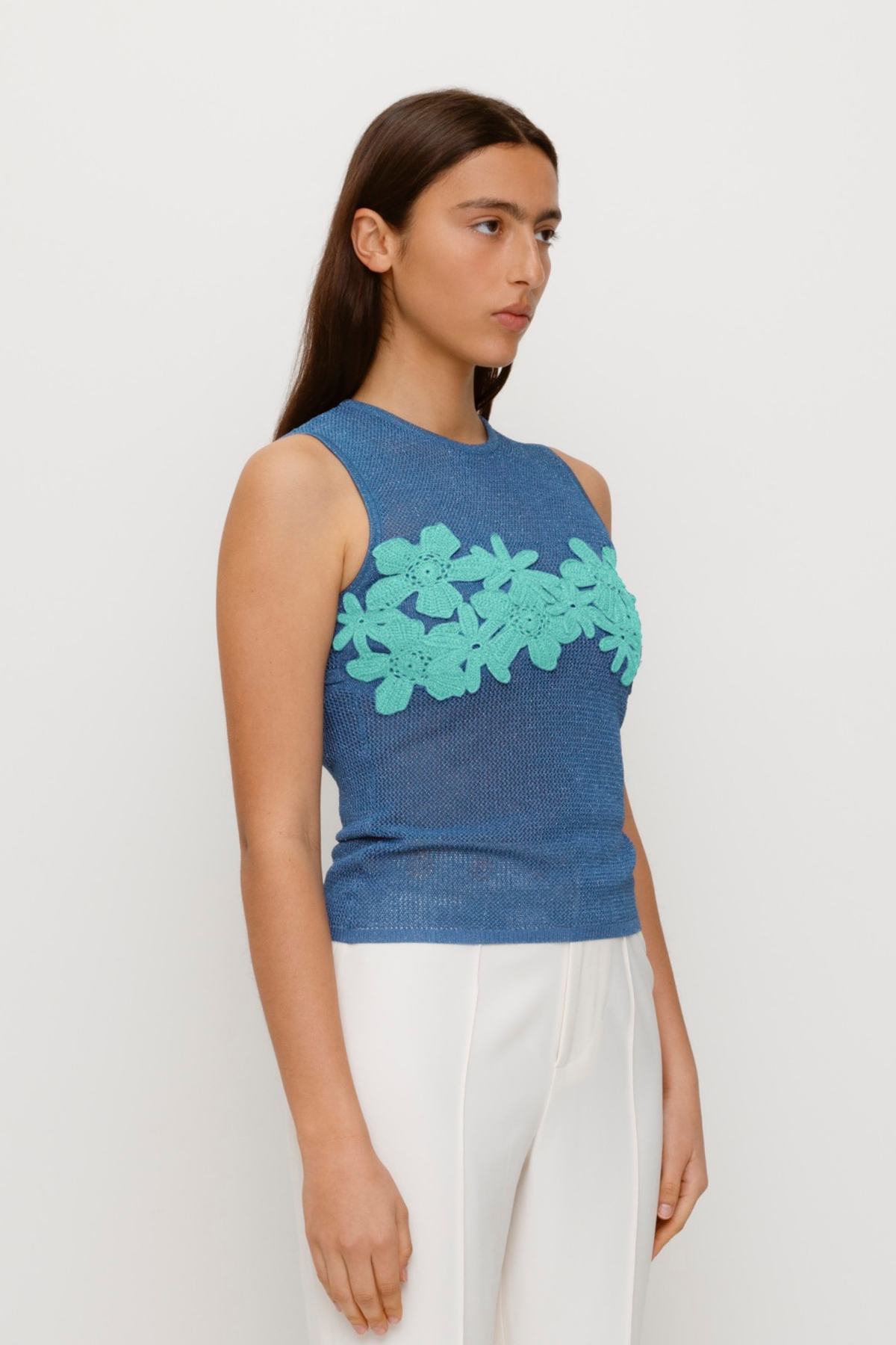 Blue stretchy knit top with 3D hand-crochet floral details and metallic lurex finish.