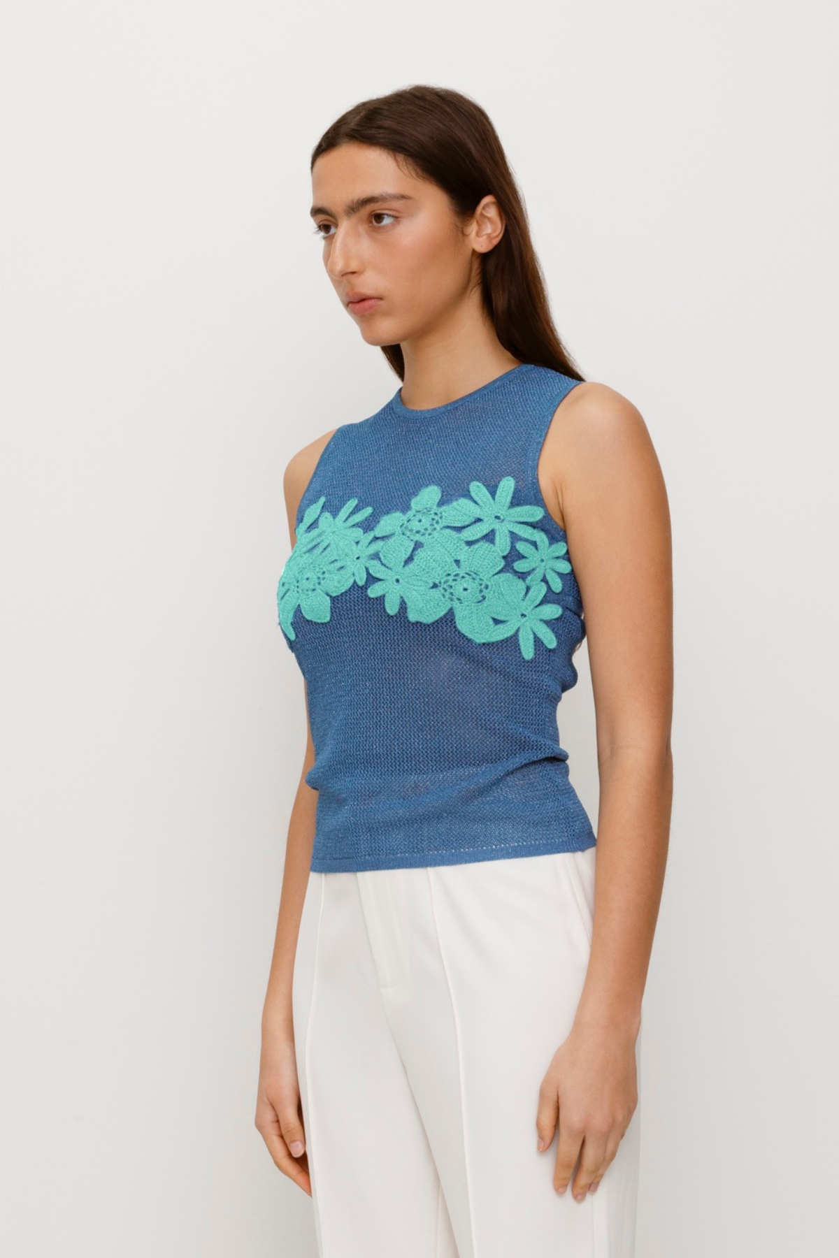 Blue stretchy knit top with 3D hand-crochet floral details and metallic lurex finish.
