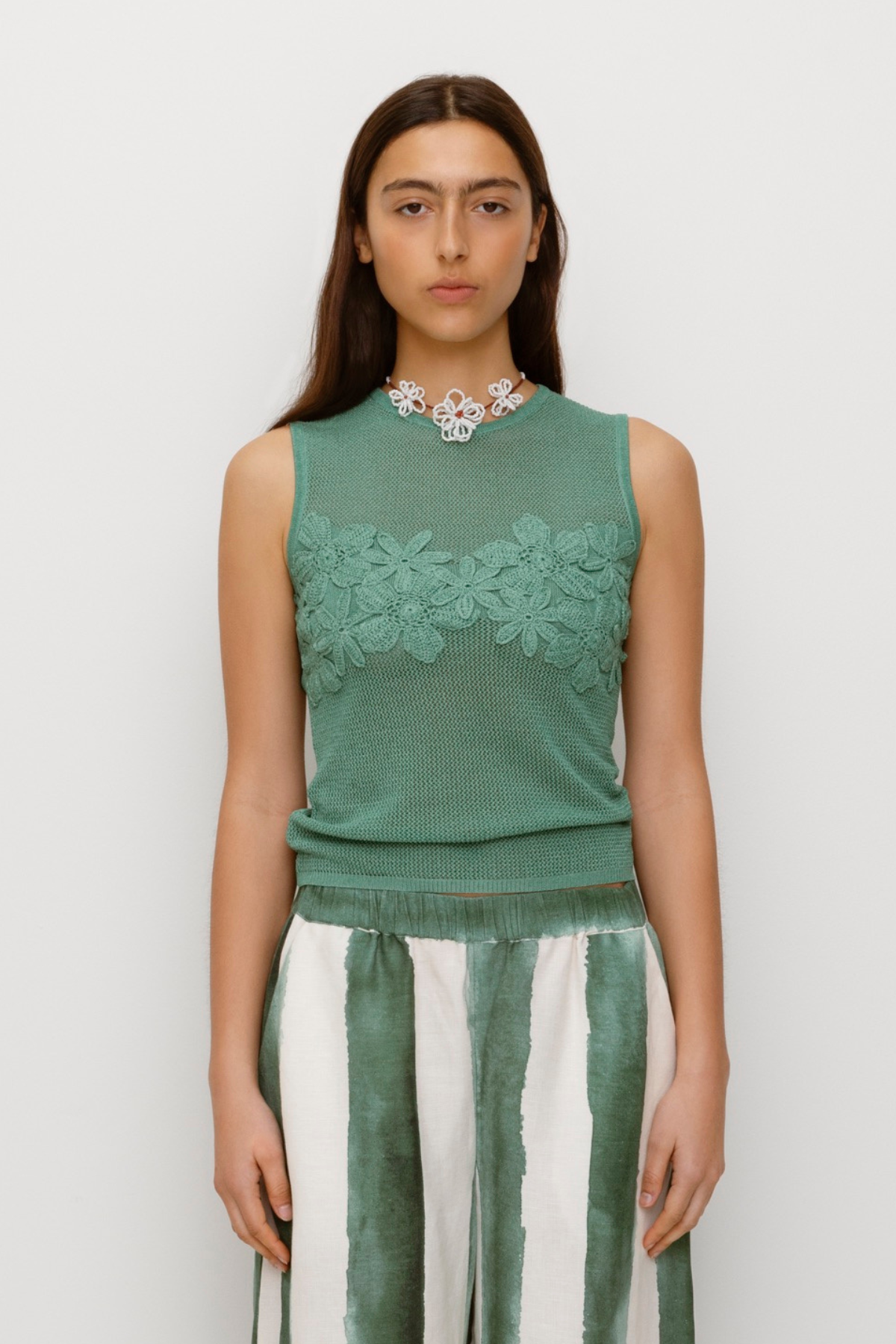 Green stretchy knit top with 3D hand-crochet floral details and metallic lurex finish.
