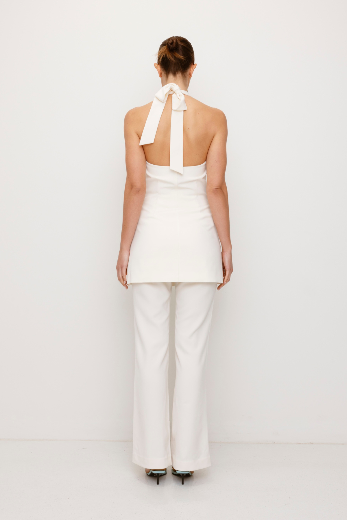 Women’s highwaisted Ivory White Irida Bootcut Pants perfect for brides with pin tuck detail and embroidered waistband—wear solo or as a matching set with Irida Vest Dress.