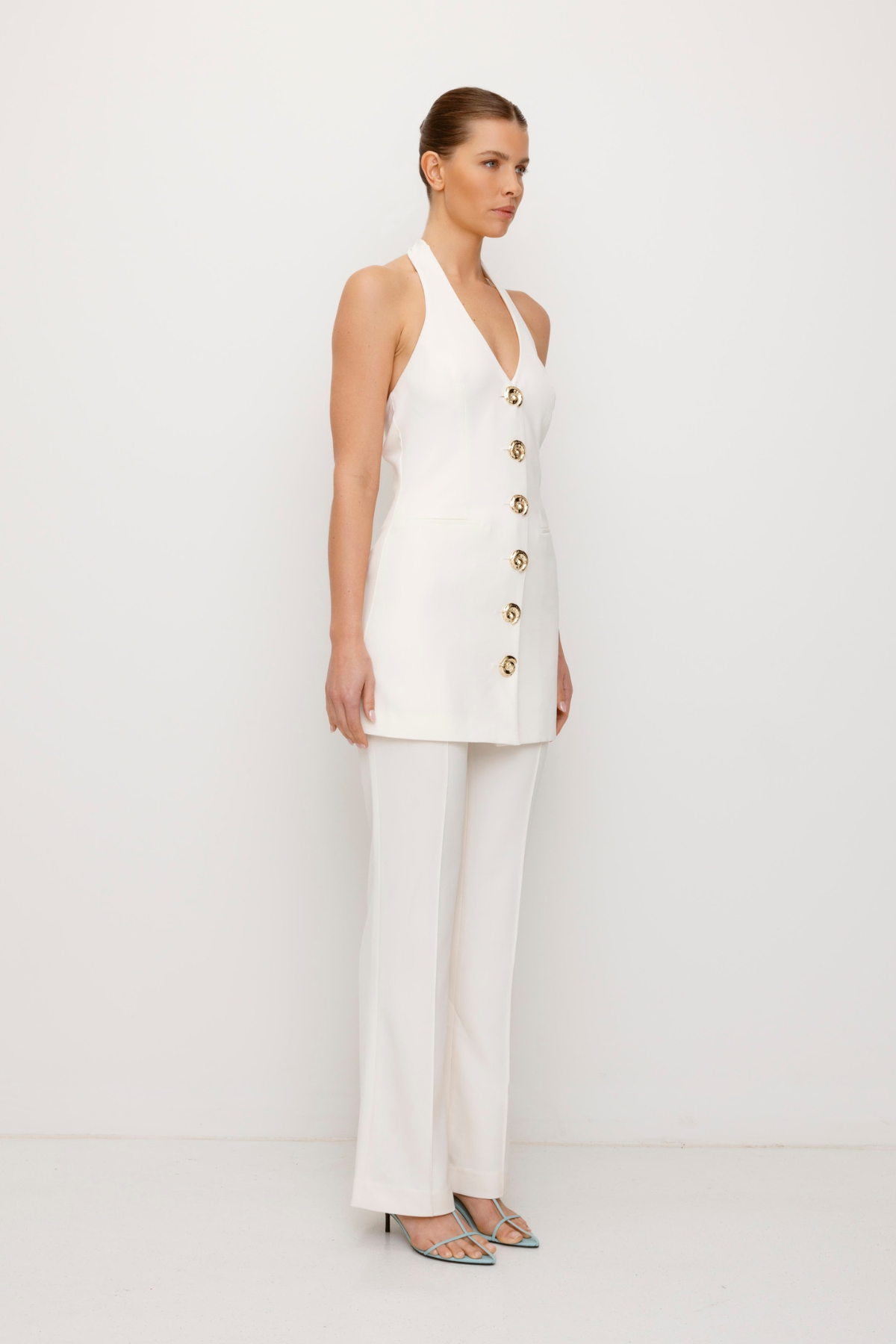 Women’s highwaisted Ivory White Irida Bootcut Pants perfect for brides with pin tuck detail and embroidered waistband—wear solo or as a matching set with Irida Vest Dress.
