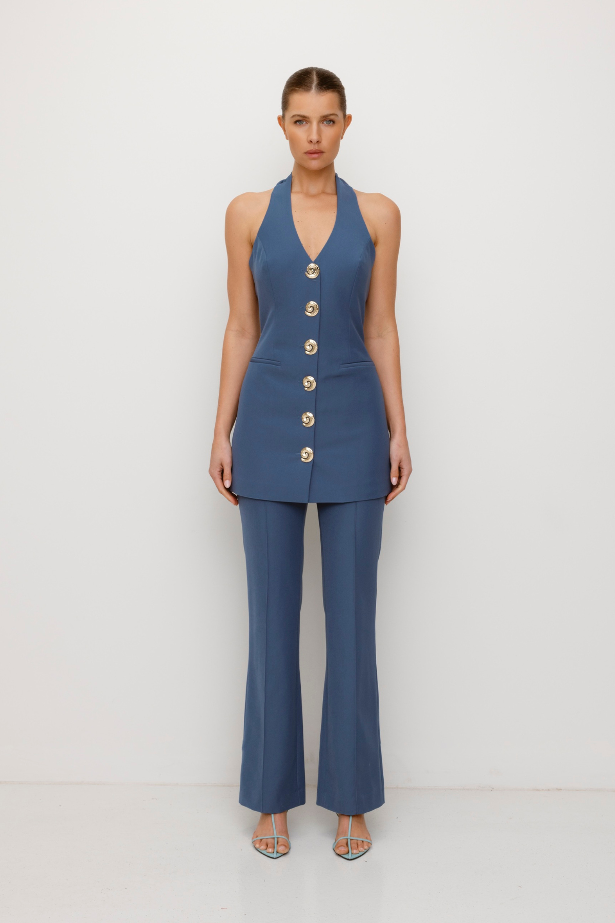 Women’s highwaisted Navy Blue Stone Irida Bootcut Pants with pin tuck detail and embroidered waistband—wear solo or as a matching set with Irida Vest Dress.