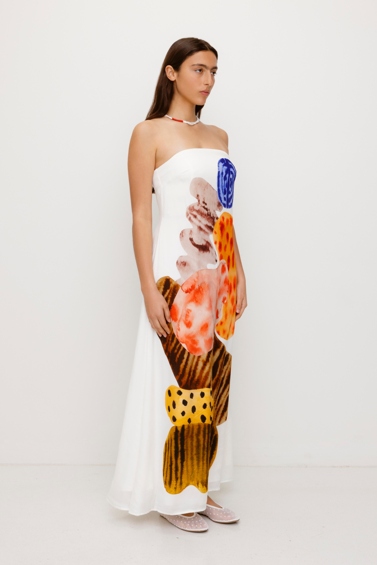 Women’s strapless White Kora Maxi Dress with asymmetric cowl neckline, abstract print, and invisible zip—perfect for events or long lunches.
