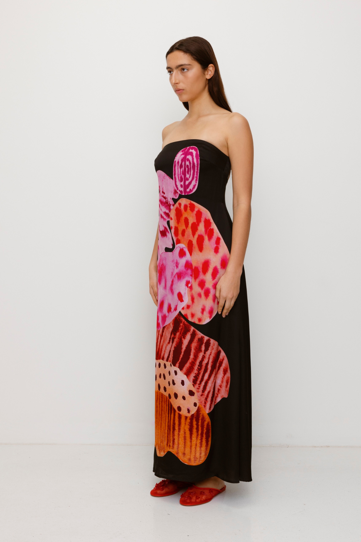 Women’s strapless Black Noir Kora Maxi Dress with asymmetric cowl neckline, abstract print, and invisible zip—perfect for events or long lunches.
