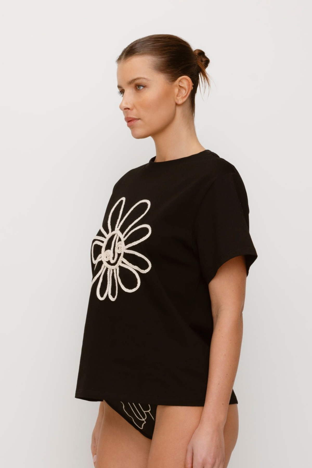 Black cotton t-shirt with rope embroidery and relaxed fit.