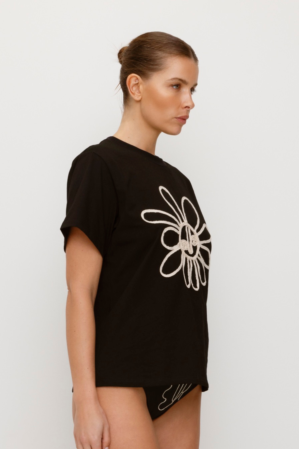 Black cotton t-shirt with rope embroidery and relaxed fit.