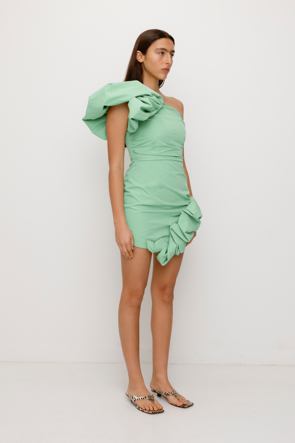 Women’s one shoulder Sage Green Octavia Mini Dress with puff shoulder detail ruffled hem rouched body and invisible back zip for easy wear.