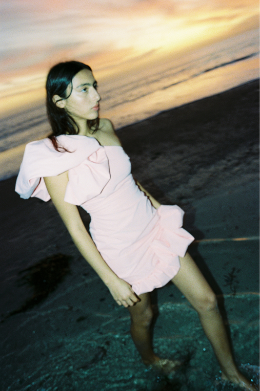 Women’s one shoulder Pink Salmon Octavia Mini Dress with puff shoulder detail ruffled hem rouched body and invisible back zip for easy wear.