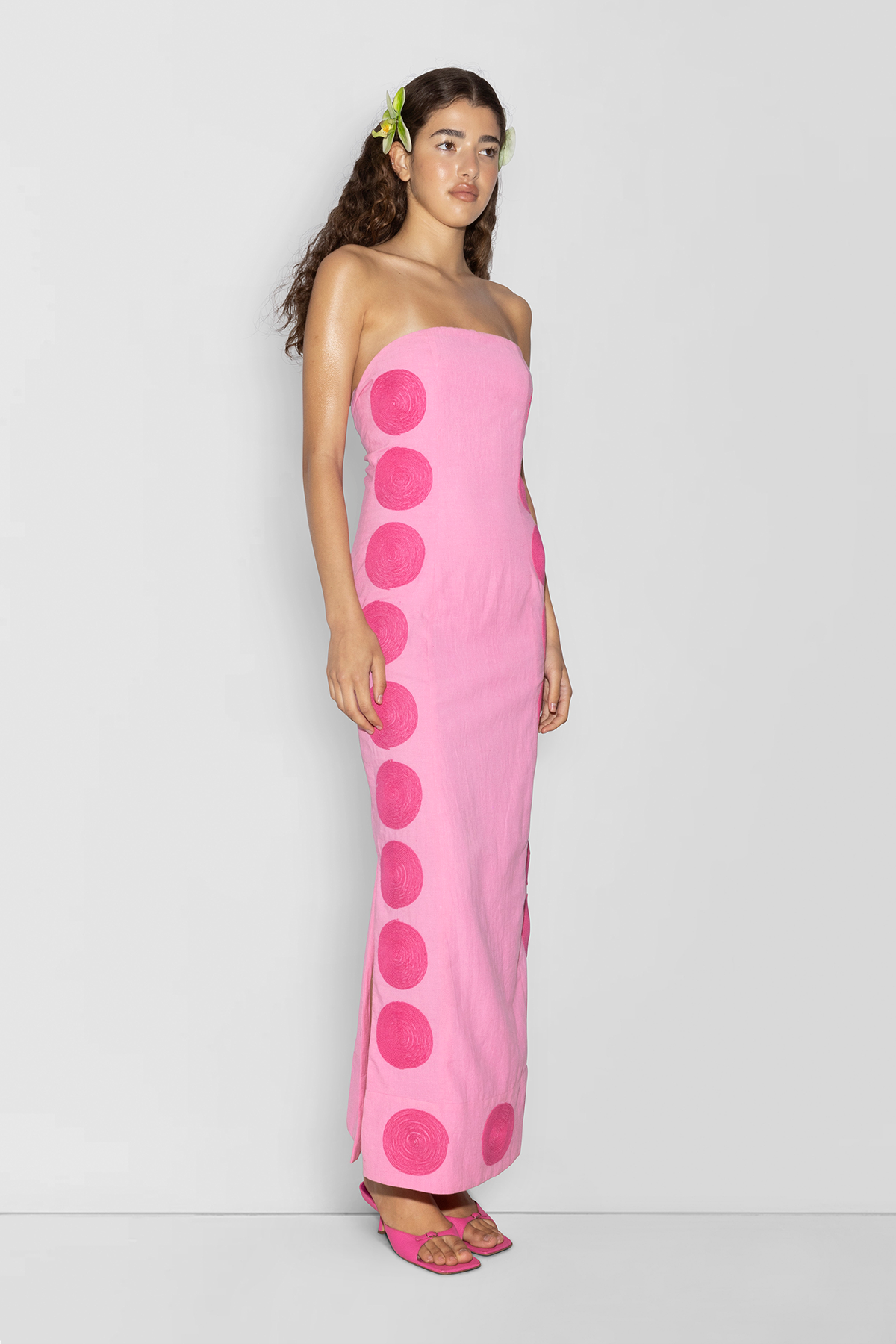 Woman wearing Pink linen cotton maxi dress with contrast embroidery and shaped bust.