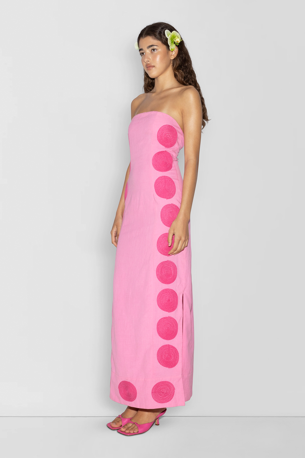 Woman wearing Pink linen cotton maxi dress with contrast embroidery and shaped bust.