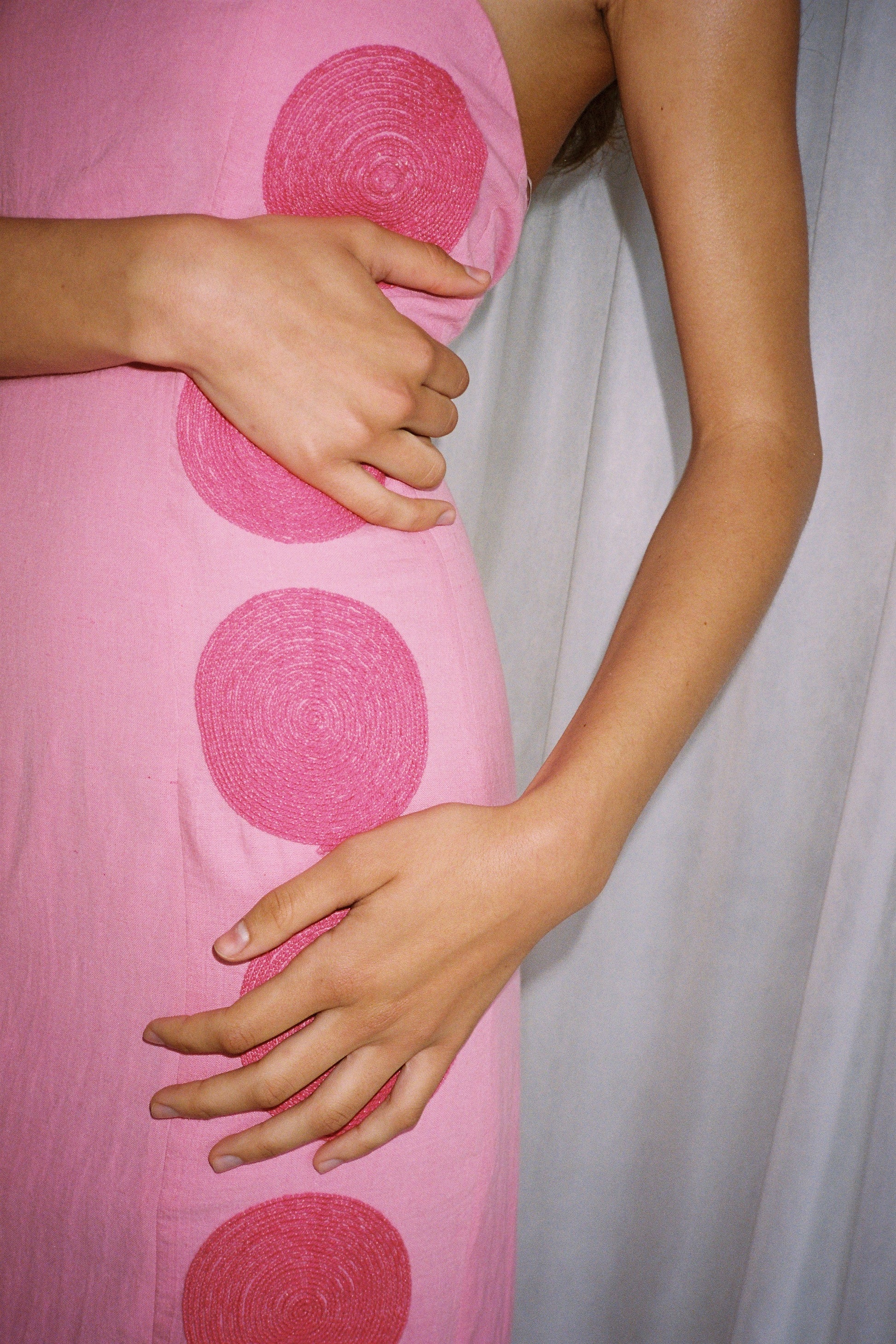 Woman wearing Pink linen cotton maxi dress with contrast embroidery and shaped bust.