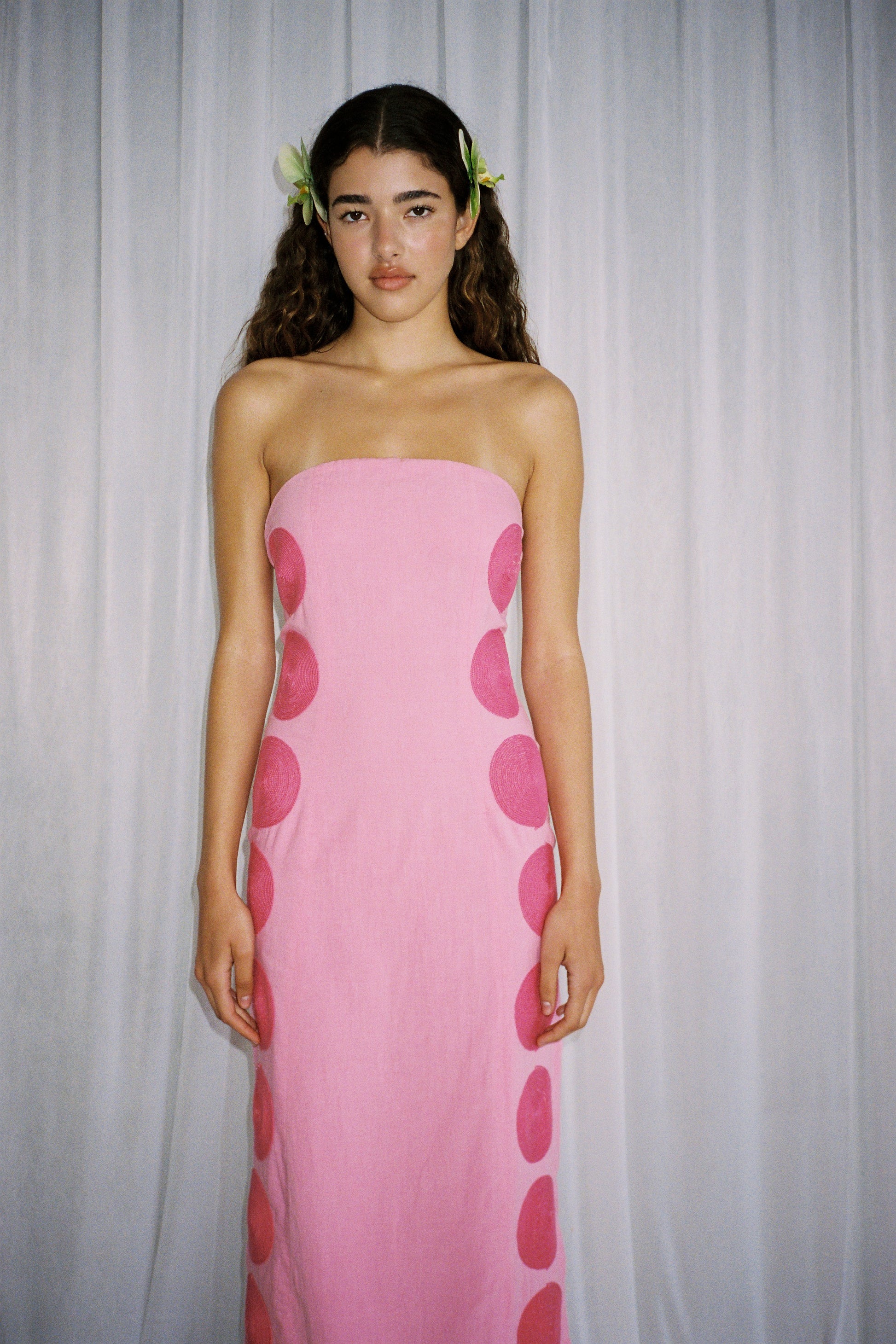 Woman wearing Pink linen cotton maxi dress with contrast embroidery and shaped bust.