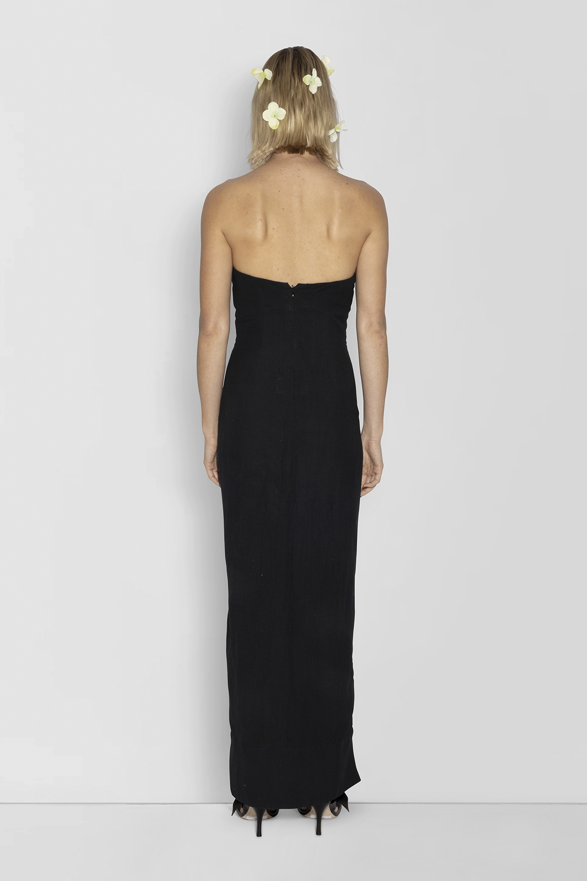Woman wearing black linen cotton maxi dress with contrast embroidery and shaped bust.