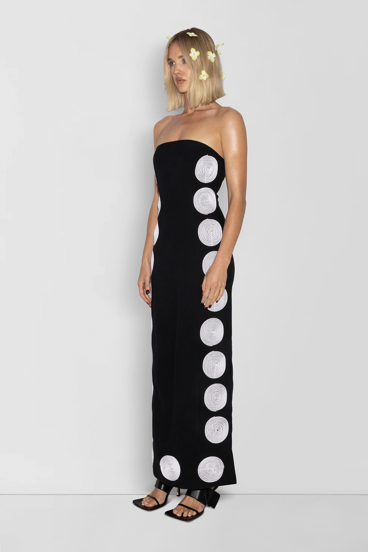 Woman wearing black linen cotton maxi dress with contrast embroidery and shaped bust.