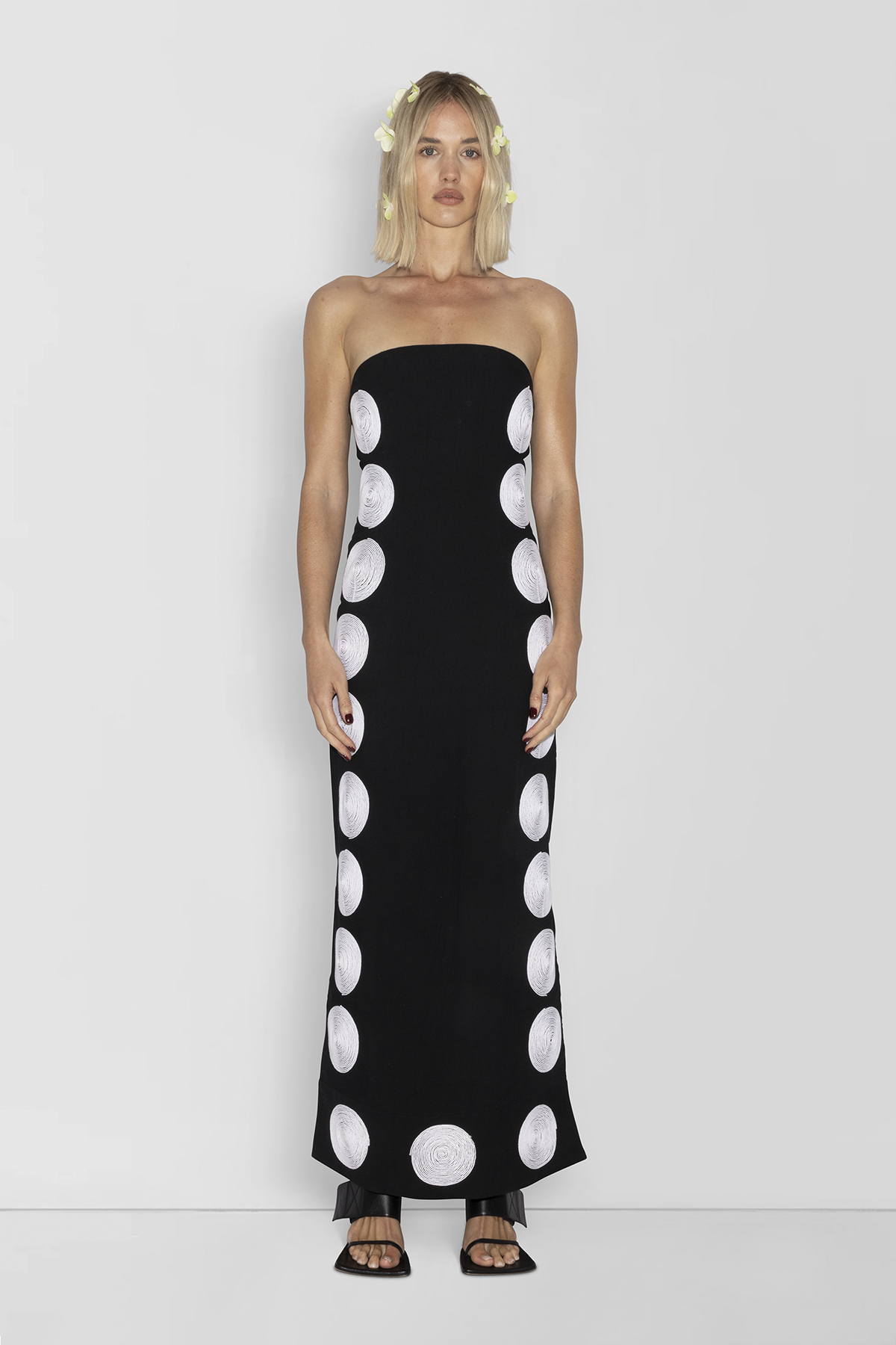 Woman wearing black linen cotton maxi dress with contrast embroidery and shaped bust.