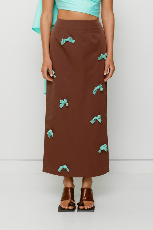 Brown high-waisted midi skirt with blue velvet bows by The Wolf Gang, styled to match the Amar One Shoulder Top.