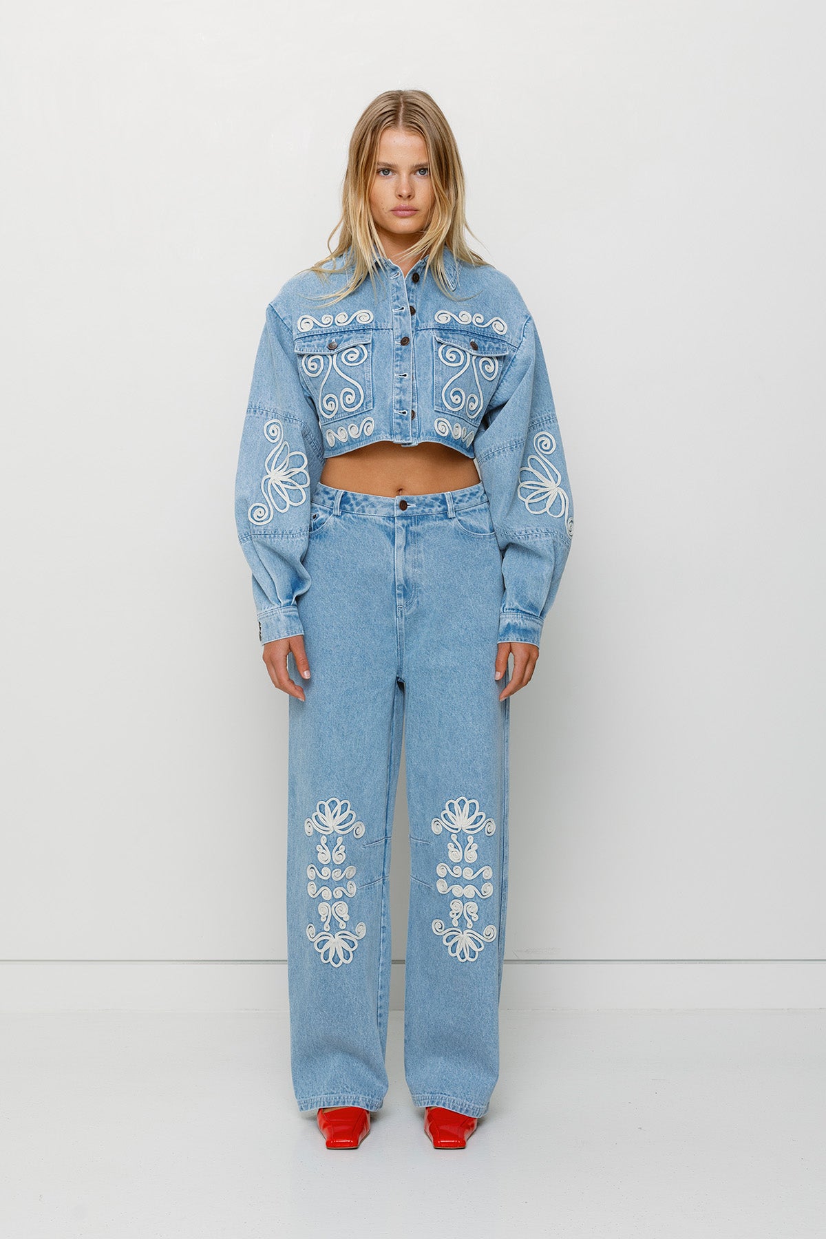 Cropped cotton denim jacket with oversized balloon sleeves and custom embroidery by The Wolf Gang, pairs with matching barrel jeans.