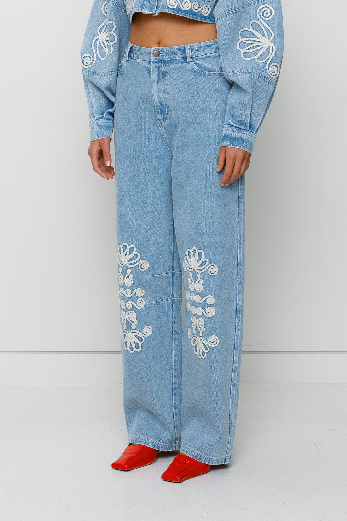 Vintage-inspired mid-rise barrel denim jeans with custom TWG embroidery and functional pockets, 100% cotton.