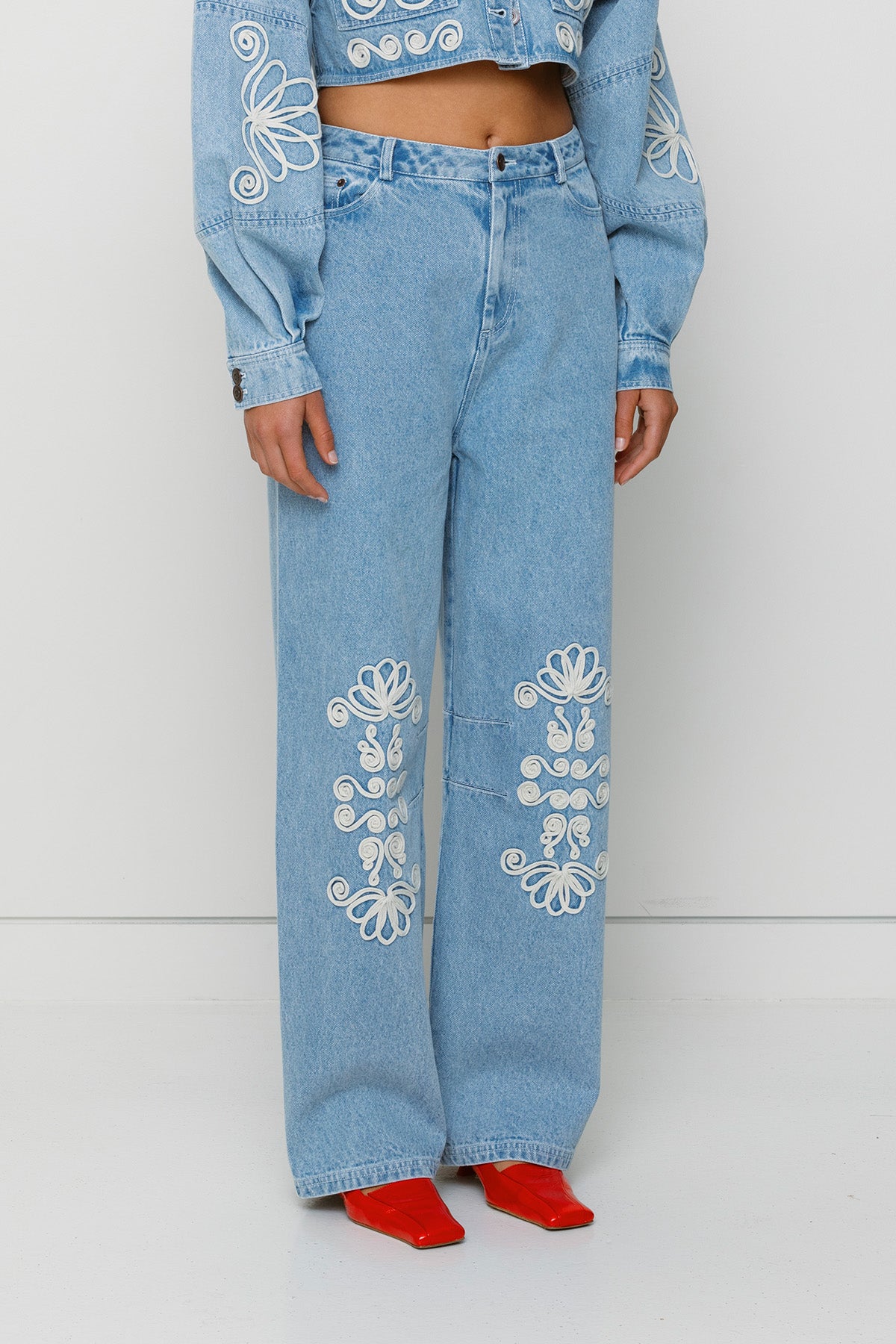 Vintage-inspired mid-rise barrel denim jeans with custom TWG embroidery and functional pockets, 100% cotton.