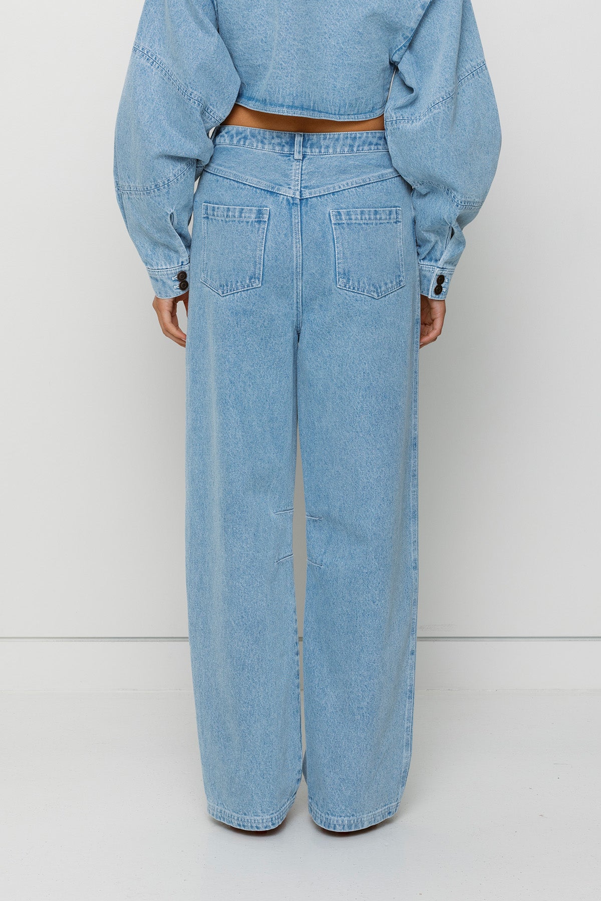 Vintage-inspired mid-rise barrel denim jeans with custom TWG embroidery and functional pockets, 100% cotton.