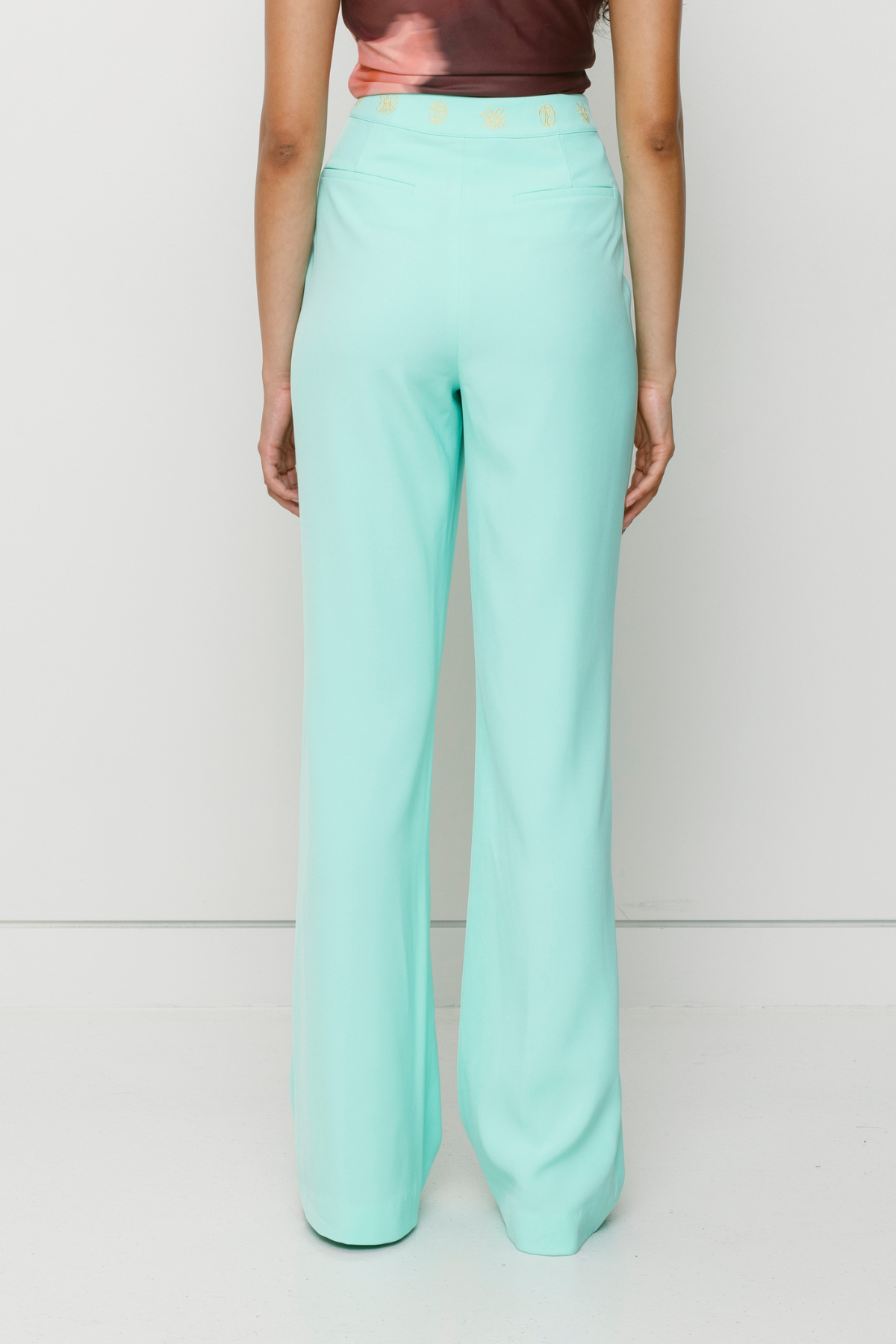 Tailored flared Inka pants with pintuck detail and custom waistband embroidery by The Wolf Gang, styled for a coordinated outfit with Inka Mini Dress.