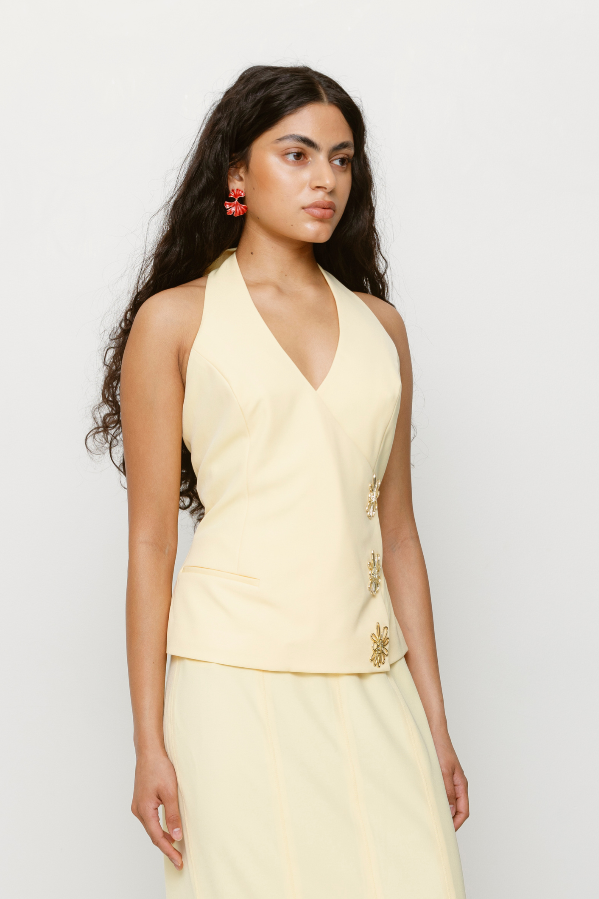 Halterneck vest top in butter yellow or charcoal grey with asymmetric closure and custom hardware by The Wolf Gang, styled with jeans or matching skirt.