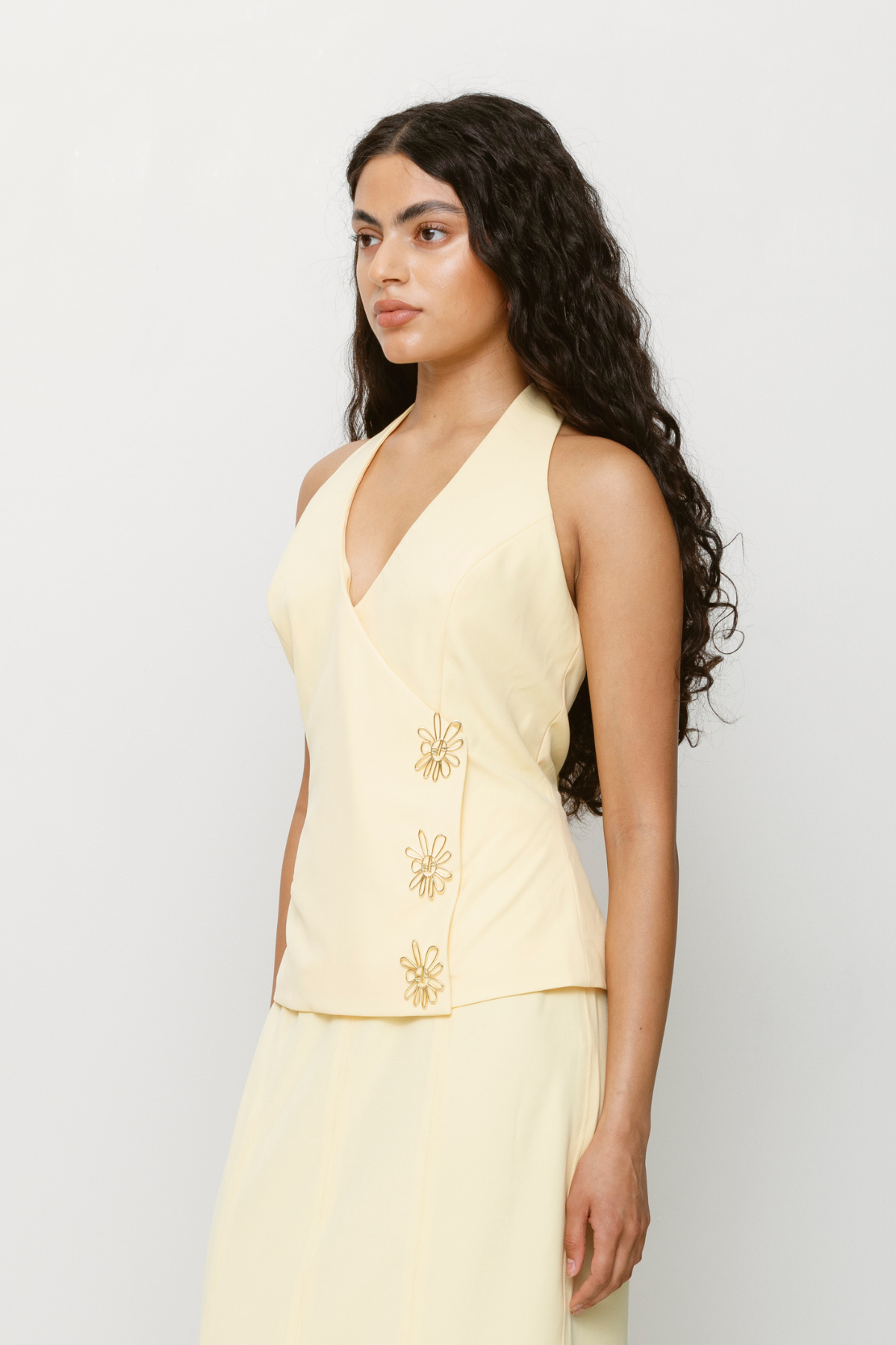 Halterneck vest top in butter yellow or charcoal grey with asymmetric closure and custom hardware by The Wolf Gang, styled with jeans or matching skirt.