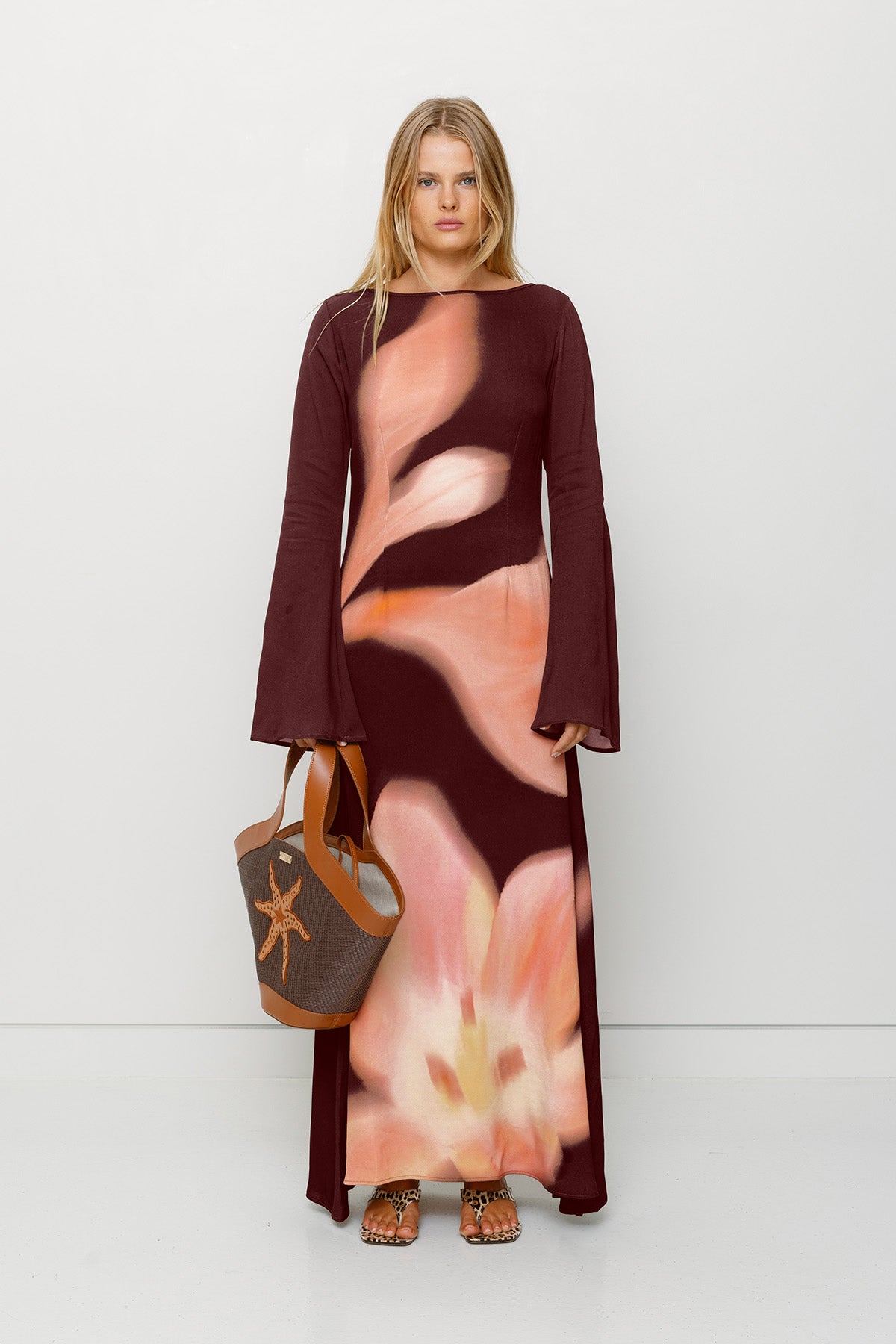 Silky sleeved maxi dress with custom floral TWG print and adjustable back tie, designed for a sleek, glamorous fit.