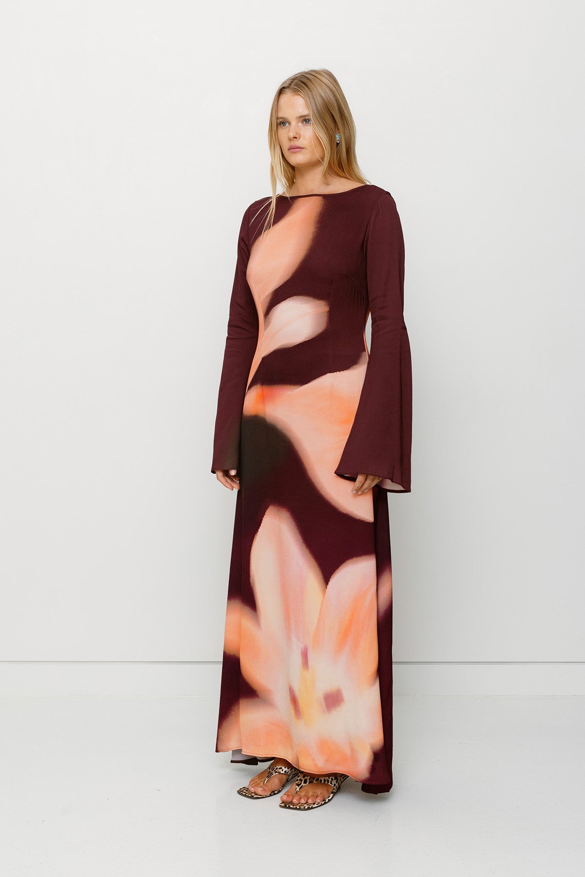 Silky sleeved maxi dress with custom floral TWG print and adjustable back tie, designed for a sleek, glamorous fit.