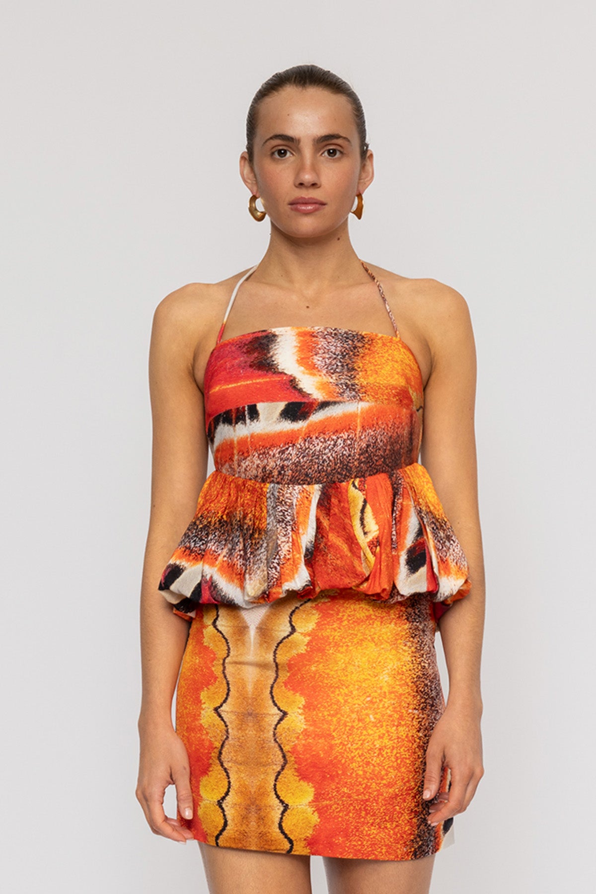 Orange multi-color halterneck blouse with bubble hem in custom TWG print by The Wolf Gang, pairs with matching skirt.