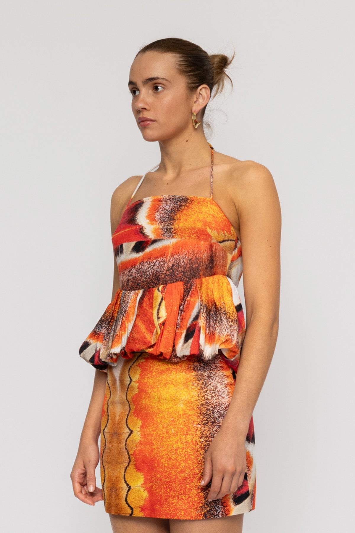 Orange multi-color halterneck blouse with bubble hem in custom TWG print by The Wolf Gang, pairs with matching skirt.