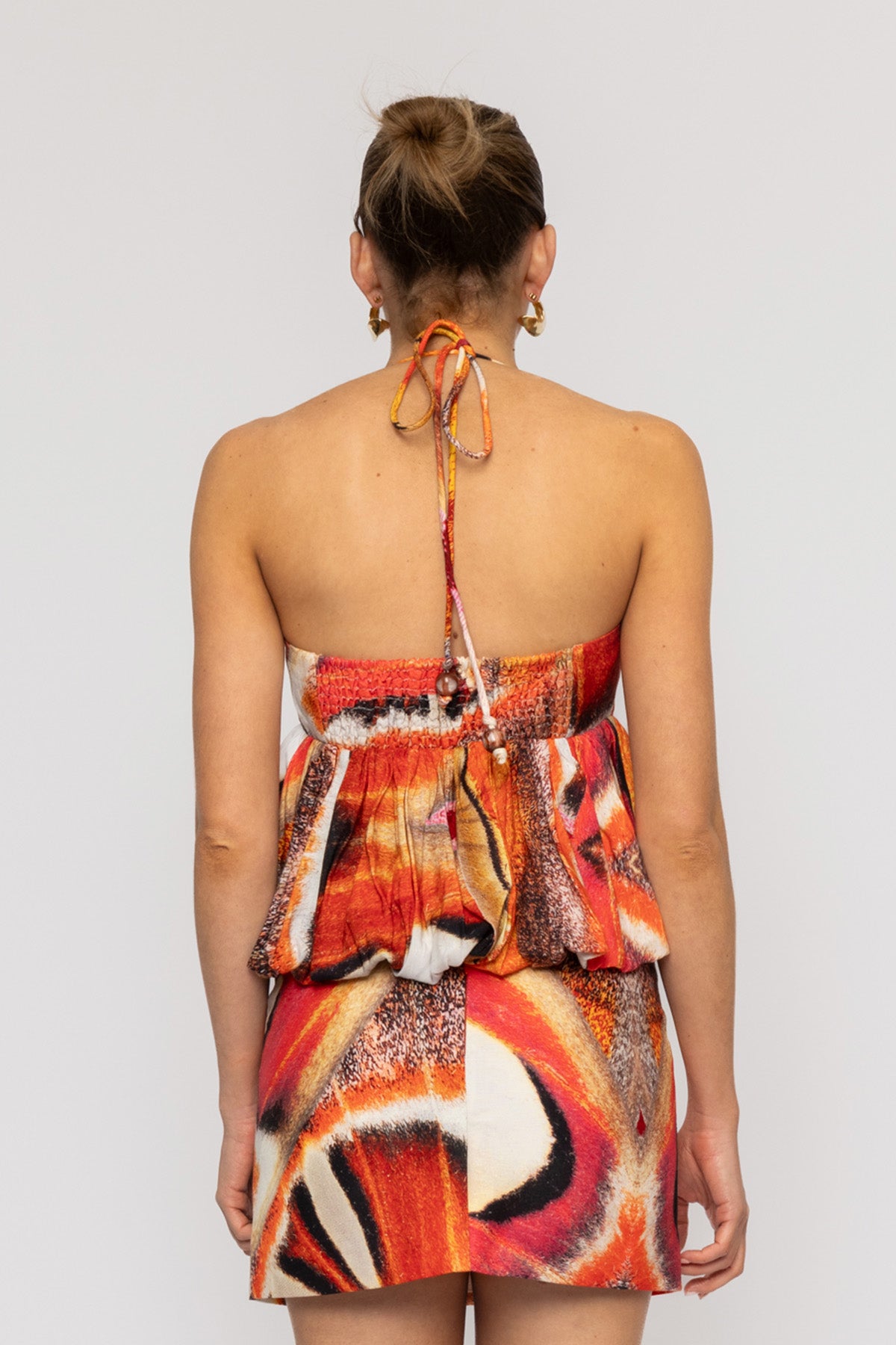 Orange multi-color halterneck blouse with bubble hem in custom TWG print by The Wolf Gang, pairs with matching skirt.