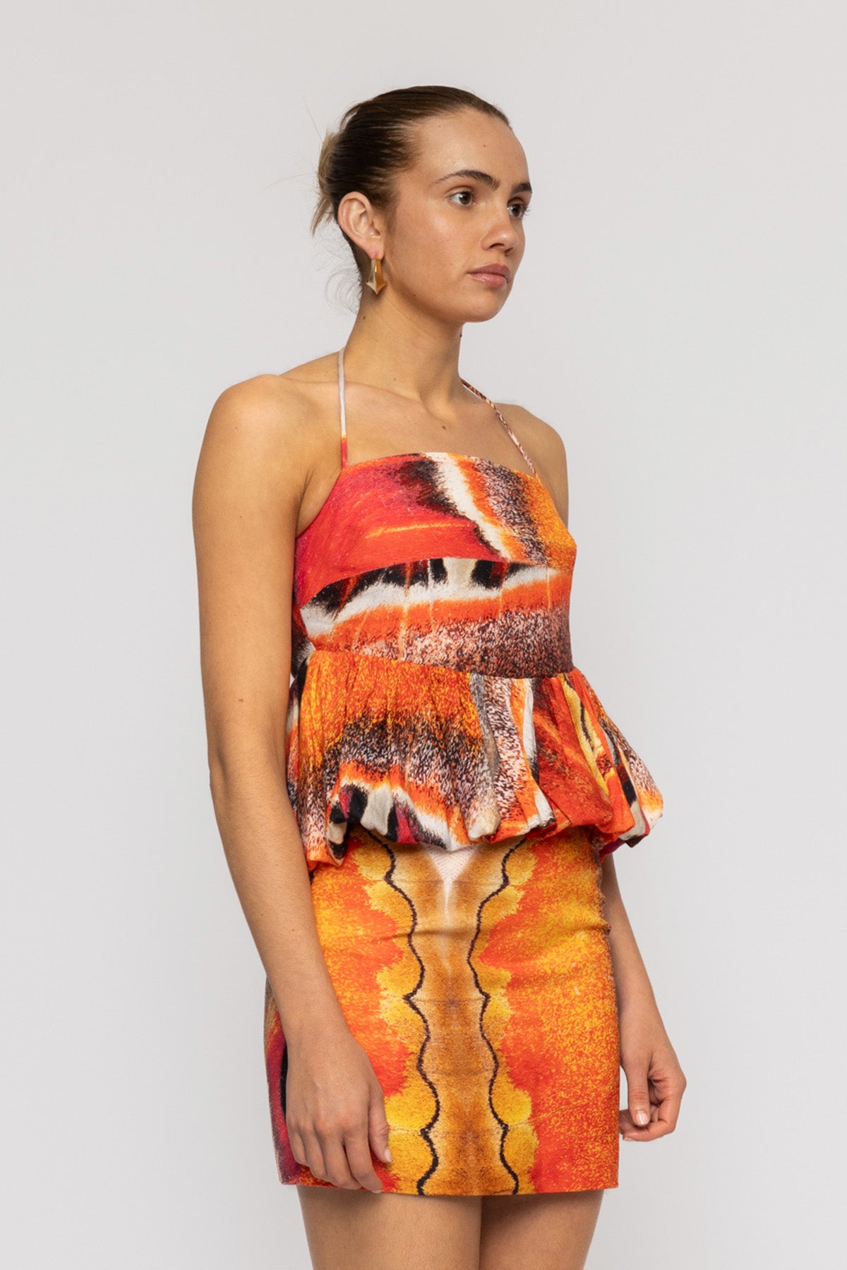 Orange multi-color halterneck blouse with bubble hem in custom TWG print by The Wolf Gang, pairs with matching skirt.