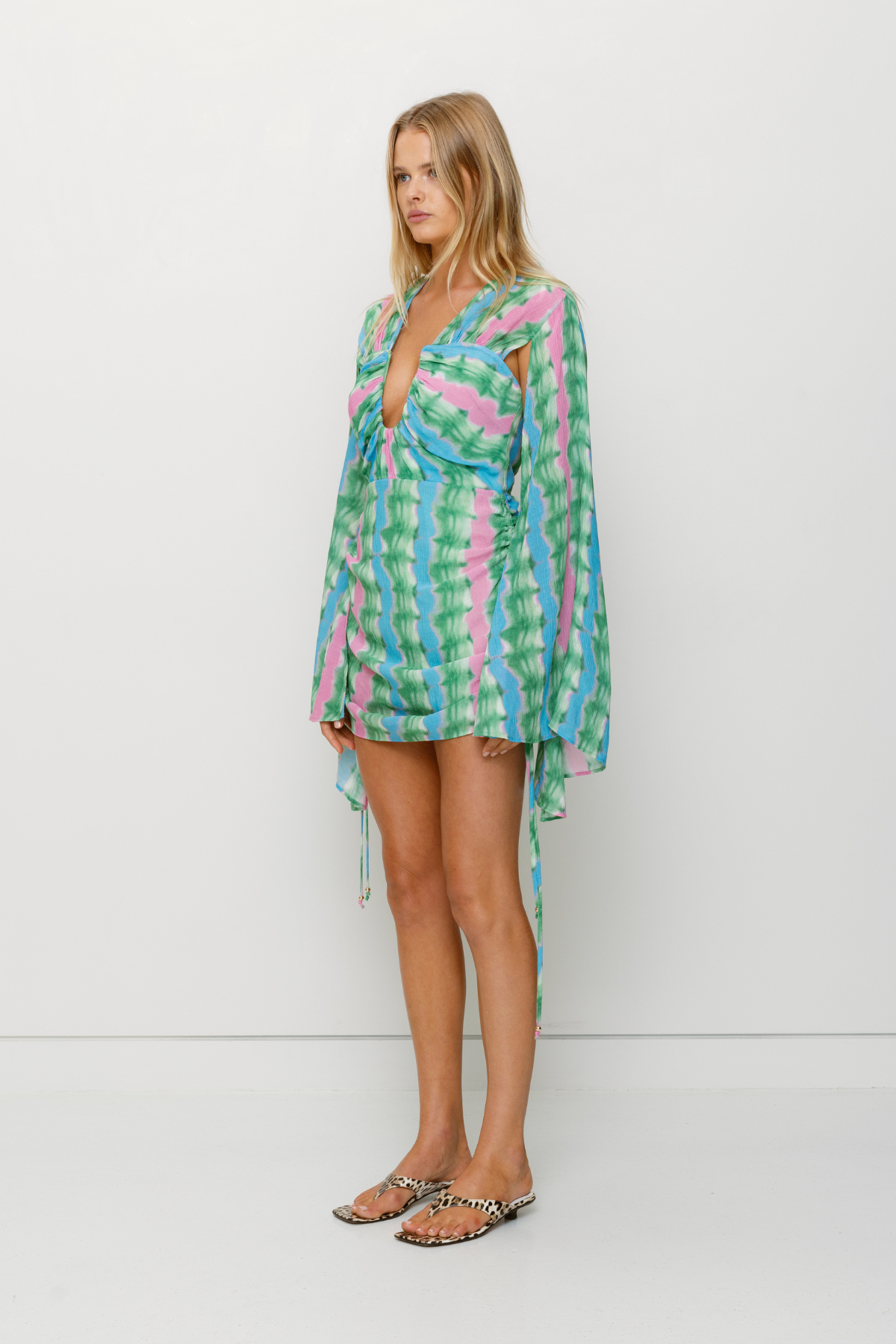 Women's tie-dye mini dress with ruched skirt and cape sleeves by The Wolf Gang, perfect for parties and nights out.