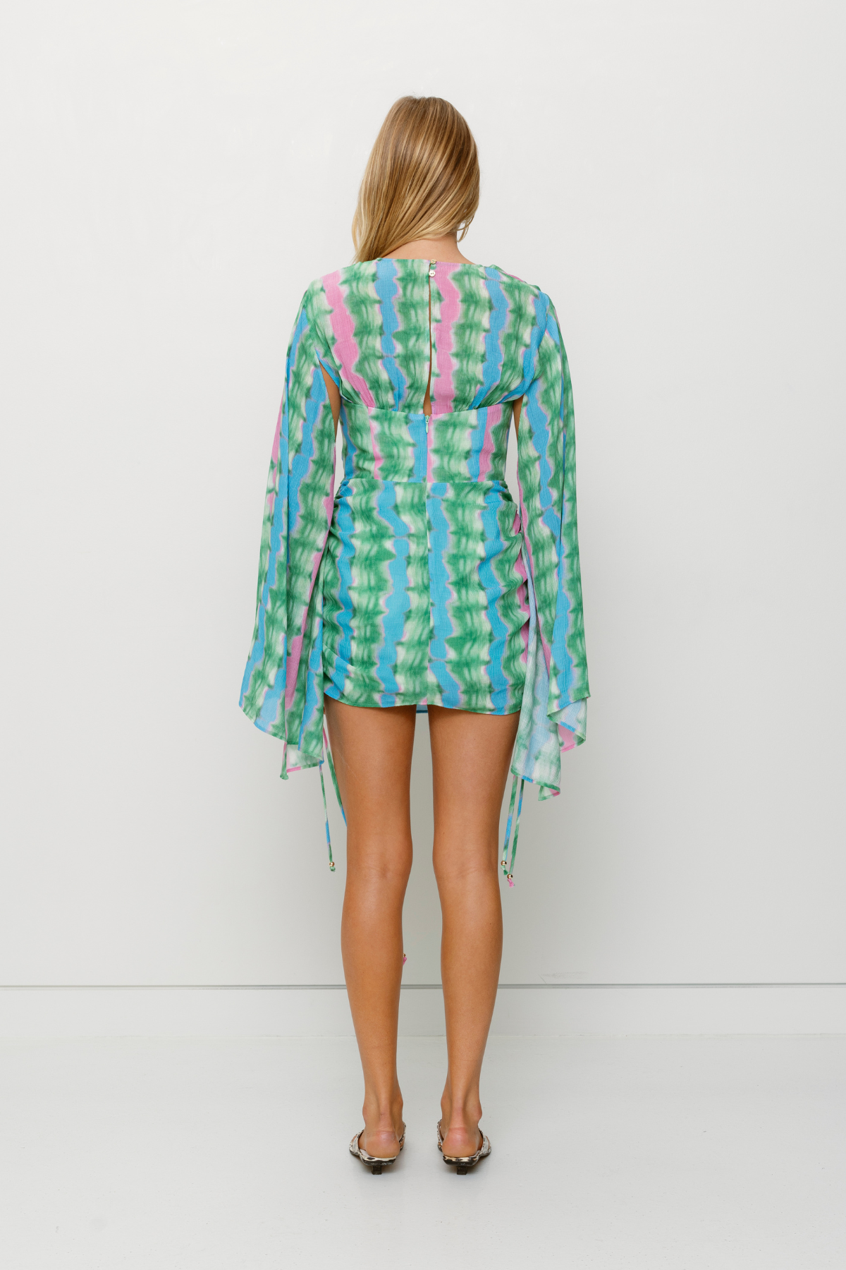 Women's tie-dye mini dress with ruched skirt and cape sleeves by The Wolf Gang, perfect for parties and nights out.