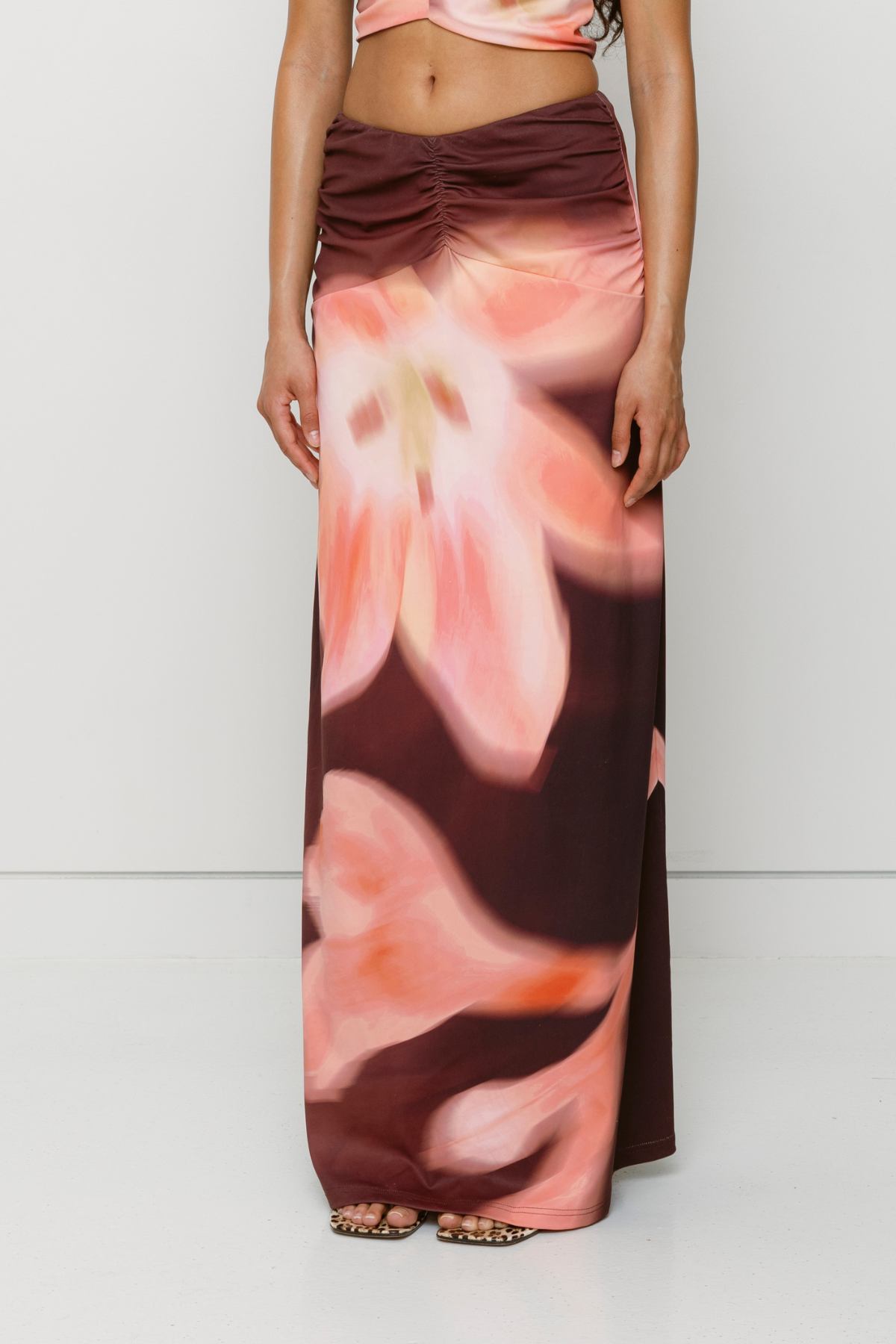 Brown floral print ruched maxi skirt with figure-hugging fit by The Wolf Gang, pairs with matching Veda Top for an event-ready look.