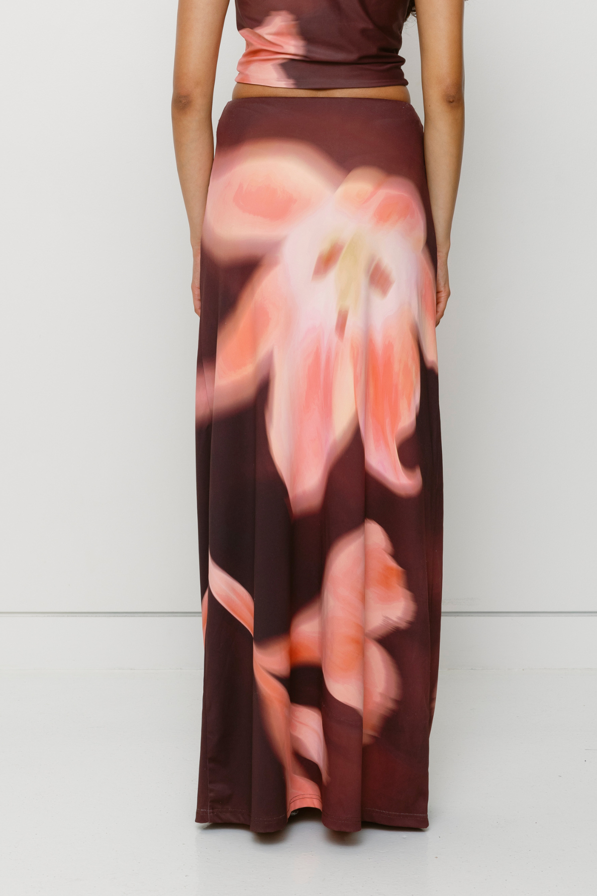 Brown floral print ruched maxi skirt with figure-hugging fit by The Wolf Gang, pairs with matching Veda Top for an event-ready look.