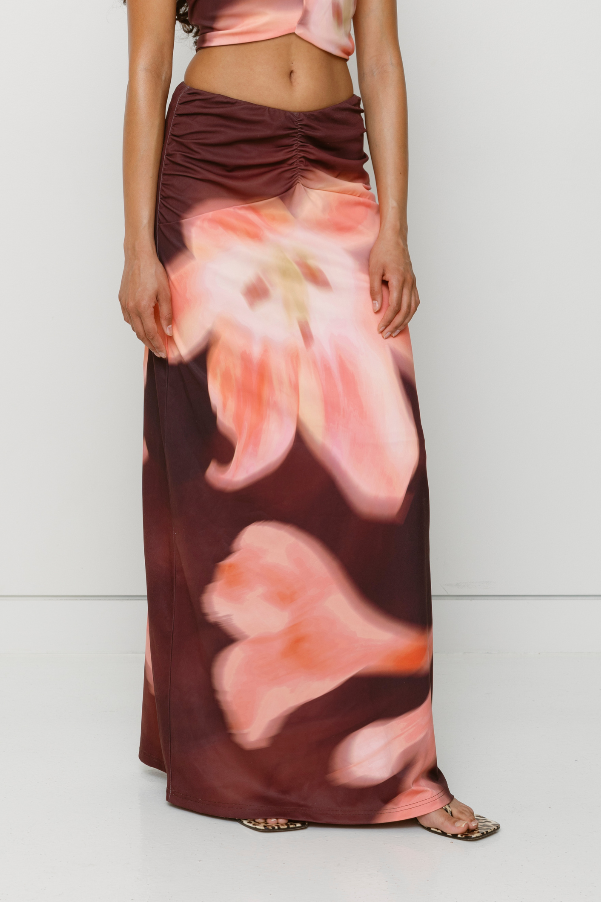 Brown floral print ruched maxi skirt with figure-hugging fit by The Wolf Gang, pairs with matching Veda Top for an event-ready look.
