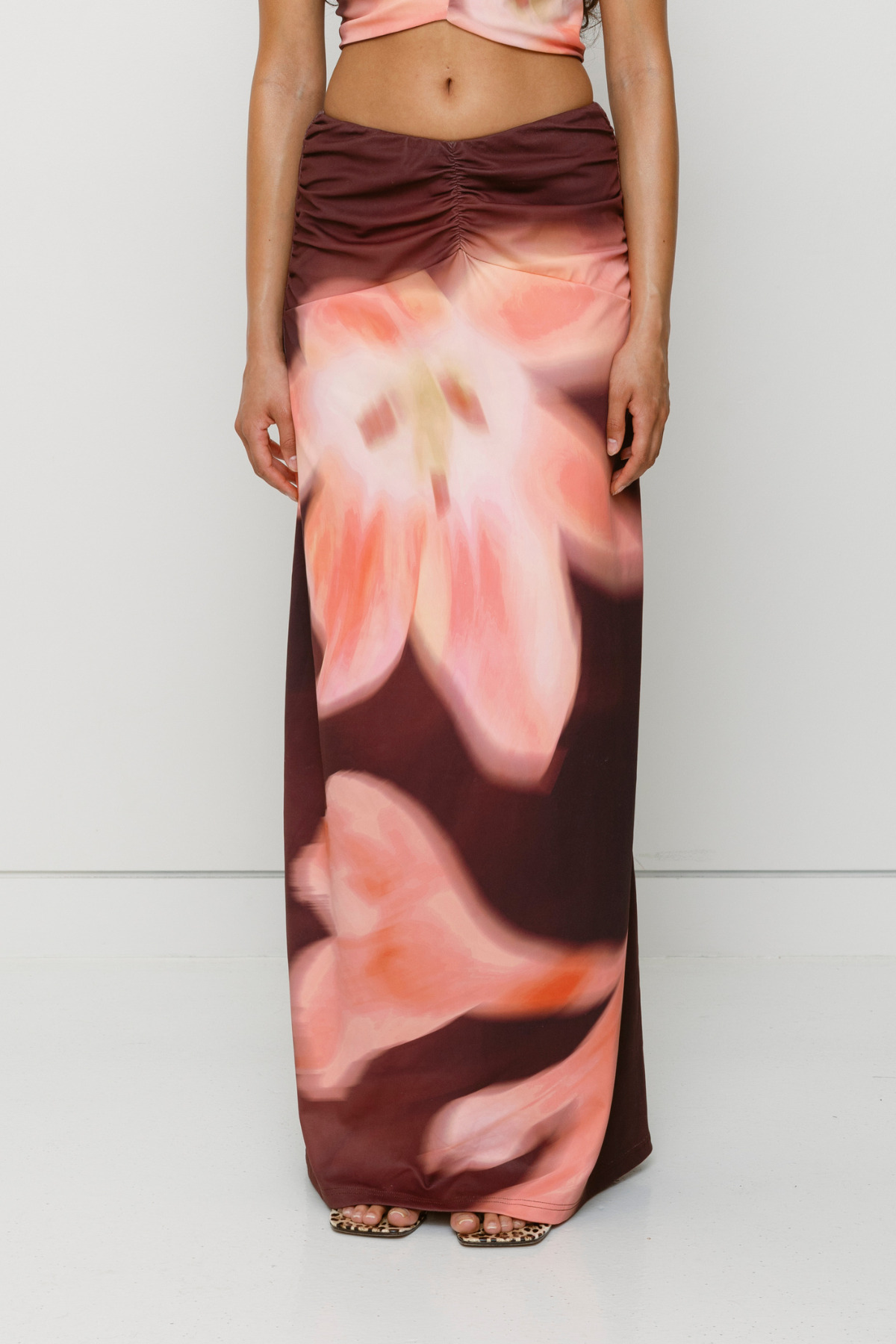Brown floral print ruched maxi skirt with figure-hugging fit by The Wolf Gang, pairs with matching Veda Top for an event-ready look.