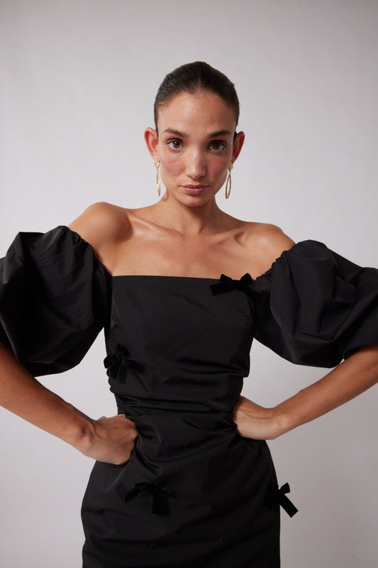 Mid-length off-shoulder dress with elasticated puff sleeves and velvet bow detail by The Wolf Gang, in pink, red, and black.