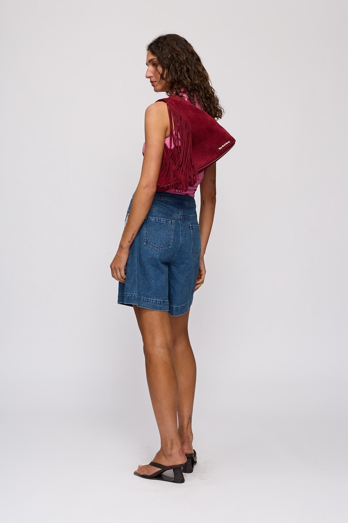 Novia Fringe Handbag in Berry by The Wolf Gang – styled back view, worn on shoulder