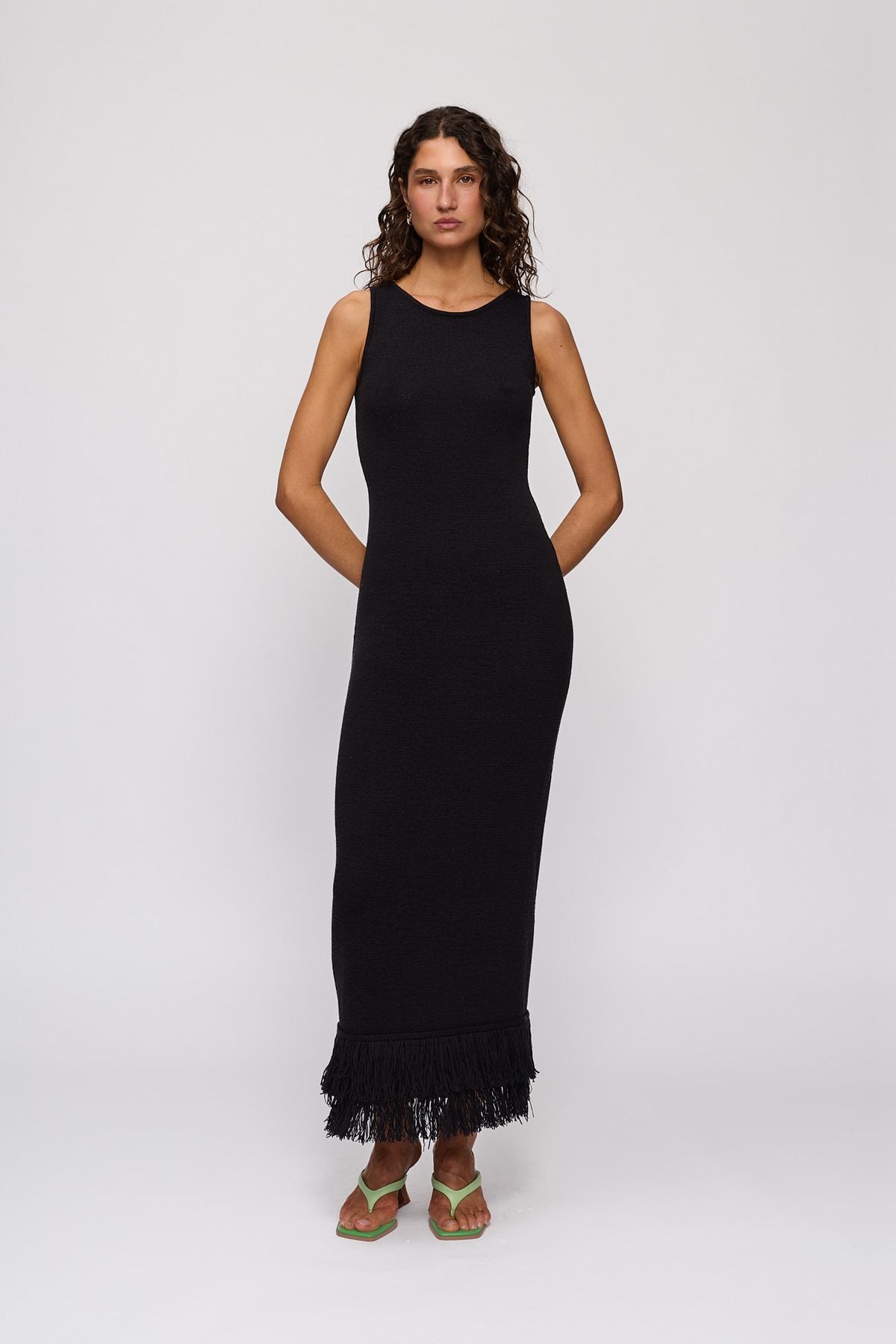 Tully Midi Dress in Noir by The Wolf Gang – front view, hands behind