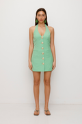 Best-selling women’s Sage Green Irida mini halter neck vest dress with gold swirl buttons, tie-back, and front welt pocket—wear alone or with matching pants.