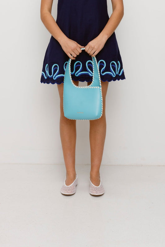 Women’s Aqua Blue Mara Shoulder Bag in 100 percent leather with twisted strap contrast binding and magnetic snap closure for everyday wear.